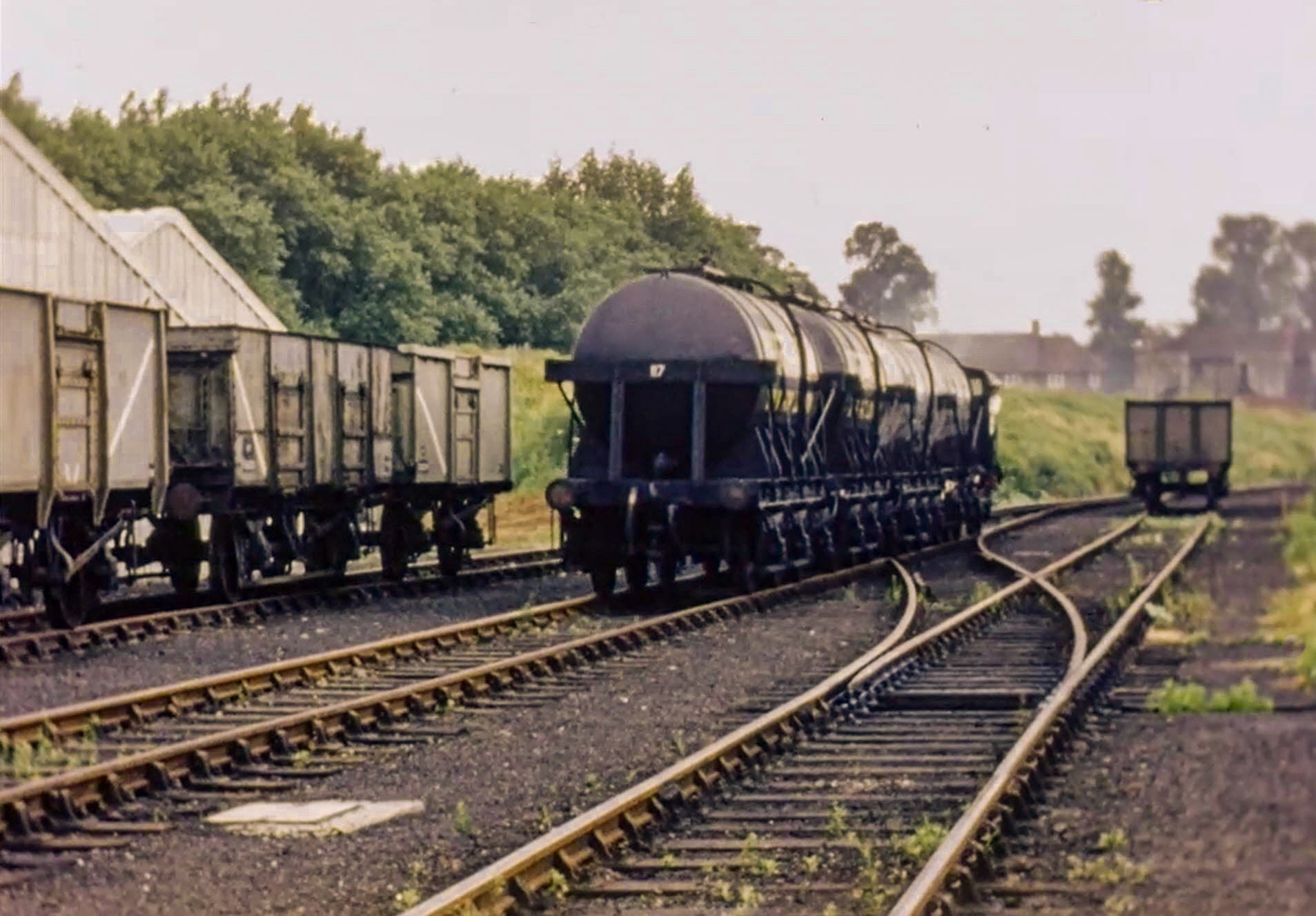 1954 South Morden Processing rail siding. Three additional tanks being shunted outside, with the dairy's own shunting engine. Coal wagons on the left for the boilers, coal-fired at that time. Roger Frost comments "The coal wagons were unloaded with a big hand-held scoop that was pulled along by a winch cable that was controlled by the operator. Hard to describe but very efficient in its operation." (Stills from Express Dairy Film)