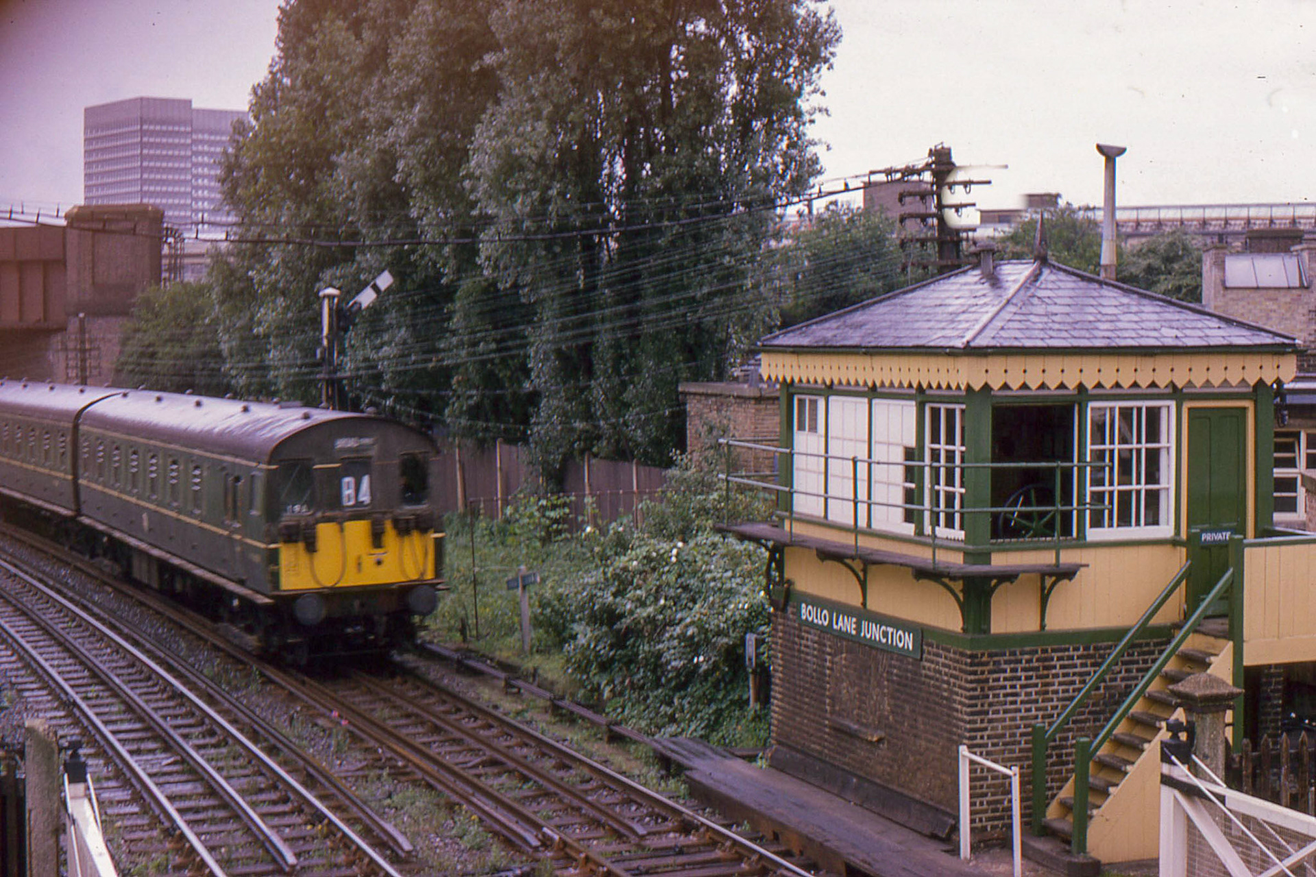 1966 A Broad Street train is seen passing Bollo Lane Junction signal box, an LSWR Type 2 box, now a listed building, in August. (Courtesy David Hawkins)
