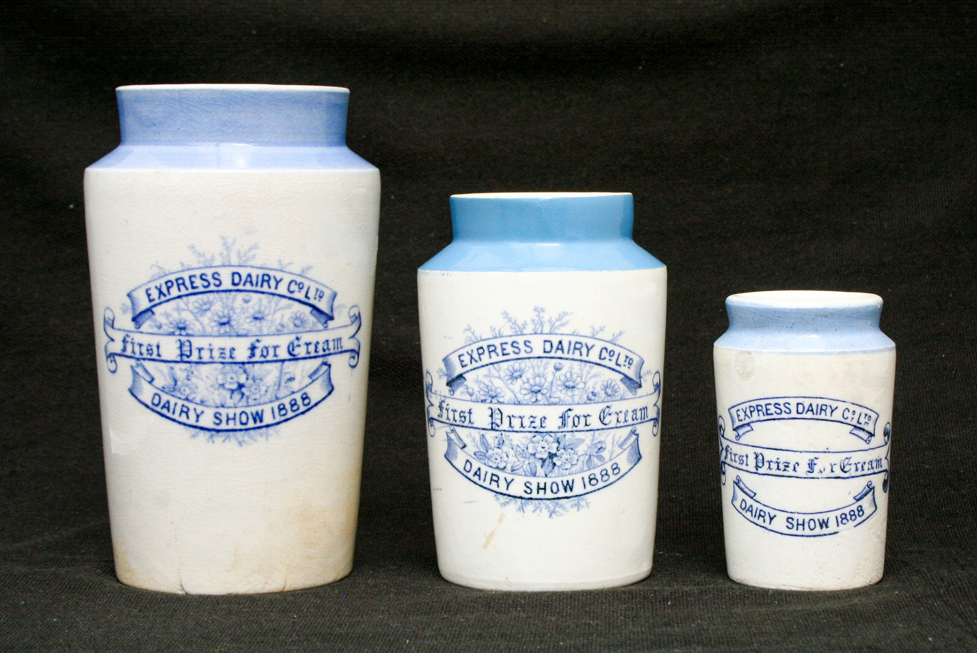 1888 Express Dairy Co. stoneware cream jars commemorating 'First Prize for Cream' at the Dairy Show.  The 'Dairy Show' was founded in 1876 and held annually at The Agricultural Hall, Islington up to the early 1930's when the show moved to the then newly built Olympia. Left jar: holds 10 fl. oz. and stands 5" high, Centre jar: holds 5 fl. oz. and stands 4" high, Right jar: holds 2.5 fl. oz. and stands 2.9" high. (Courtesy Mark Hudson)