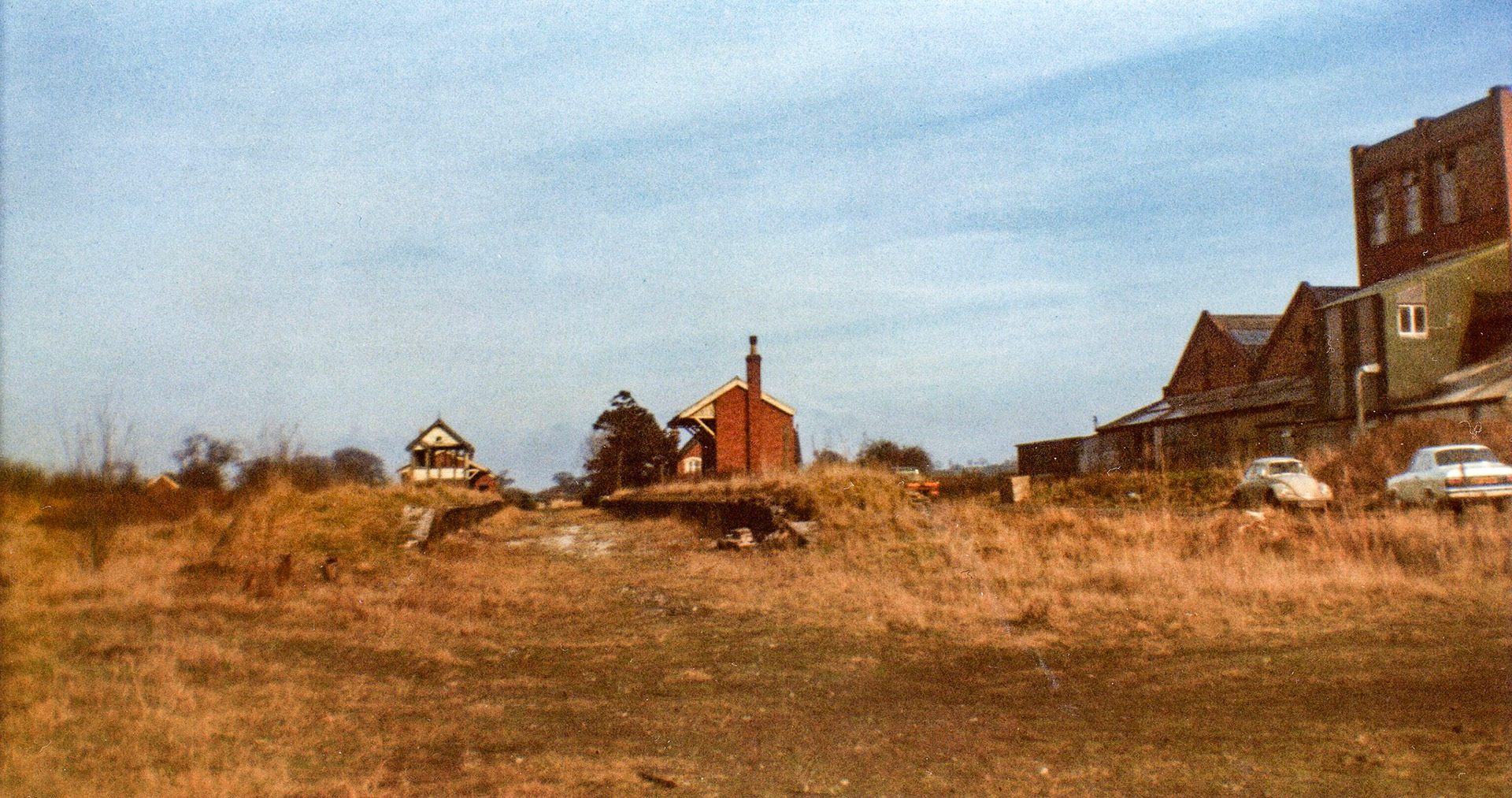 1974 Pipe Gate. Simeon comments "This is one of the few photographs I have found of our local station, Pipe Gate, between closure and demolition. The station was on the North Staffs Market Drayton to Stoke line, and passenger services were withdrawn in 1956. Specials continued to run until 1963 serving the local racecourse, before the line officially closed in 1967. The photograph was taken in 1974 and shows the signal box and the Express Dairy Creamery on the right." (Courtesy Simeon Gaskell)