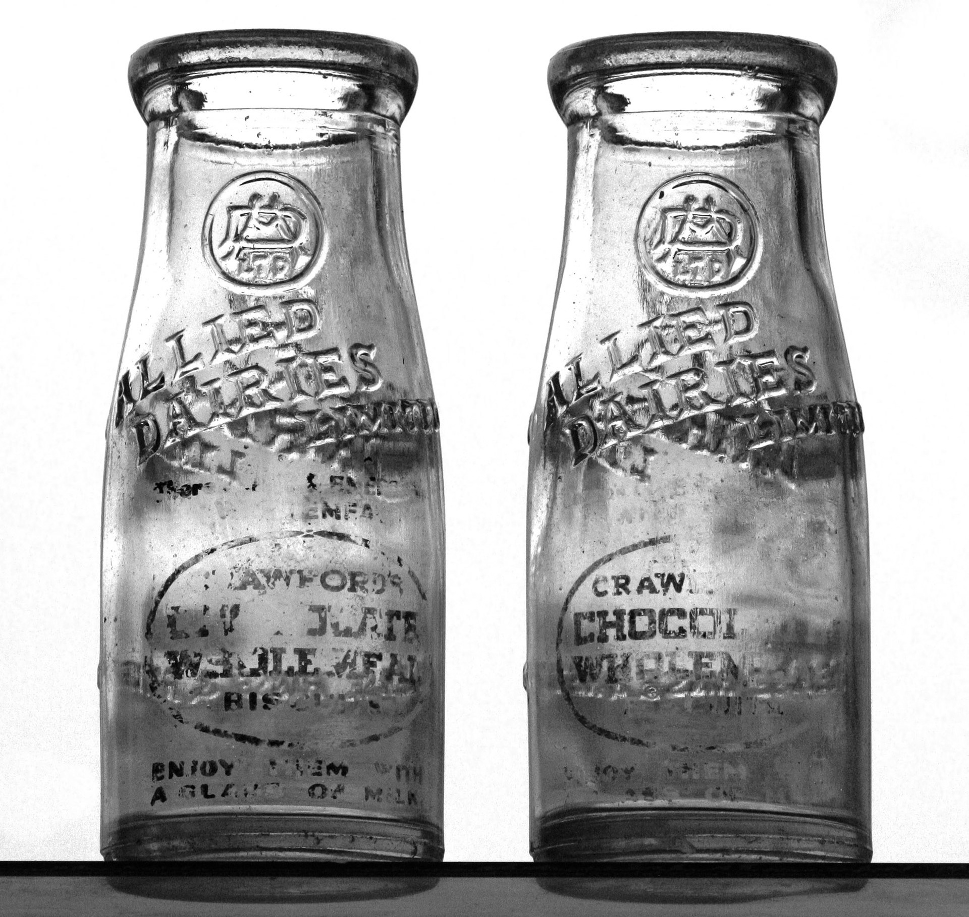 1930s Allied Dairies embossed half-pint wide neck milk bottle, sealed with a cardboard disc insert. Bottle also has an applied enamel print promotion for Crawford's Wholemeal Biscuits. (Courtesy Mark Hudson)