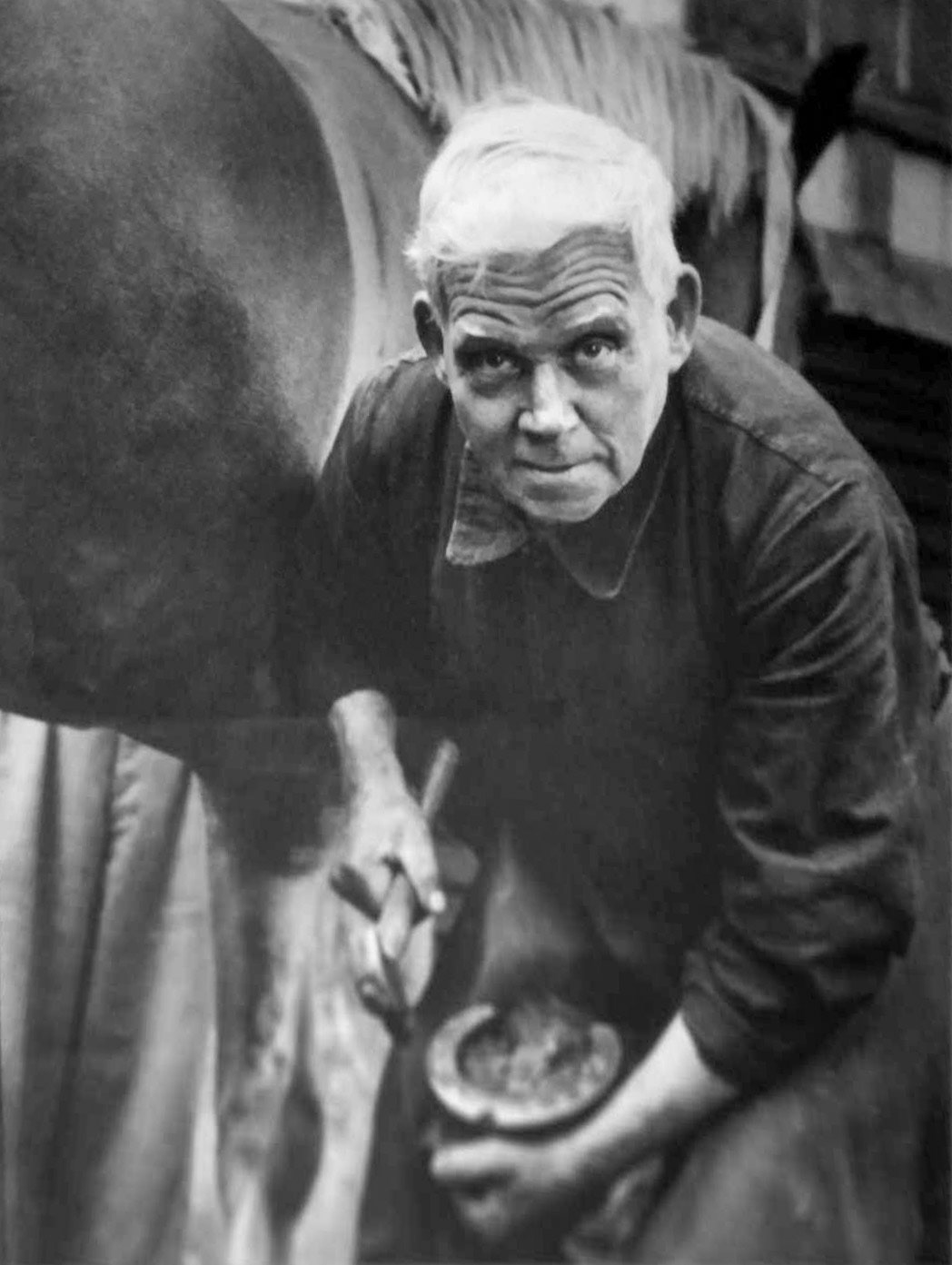 1950's Frith Manor Farm. Walter Faulkes, born in Sheffield, was blacksmith and foreman farrier at the Express Dairy Rest Home for Horses at Frith Manor Farm. Brian Wastell comments "I grew up watching him and the other farriers shoeing the horses and making the horseshoes. He was not a tall man but he seemed able to control the big horses better than the other farriers. In his youth he served in World War One, shoeing horses sometimes 16 hours a day. He also traveled to the USA for horse shoeing competitions, where he won medals. He was also employed by the Royal College of Veterinary Surgeons to make special shoes including medical aluminum plates for race horses. He worked long after retirement, preparing the show horses ready for shows. I watched him repair a broken axle on one of the show gigs, joining it the old blacksmith way. He lived at Barham Court until his death; he was one of the wonderful people employed by Express Dairy and a friend. Not be forgotten." (Courtesy Brian Wastell)