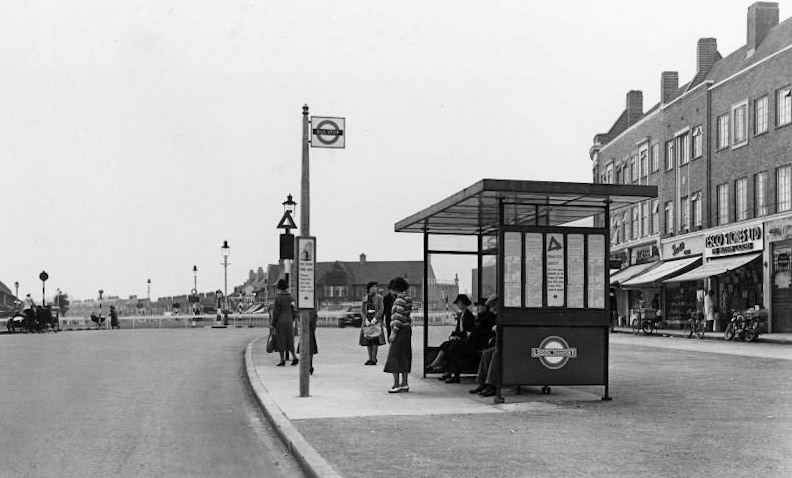 1939 Bus shelter at junction of Cambridge Road and Silver Street, Edmonton. The parade of shops on the right includes a Tesco Stores and Express Dairy. (Courtesy London Transport Collection)