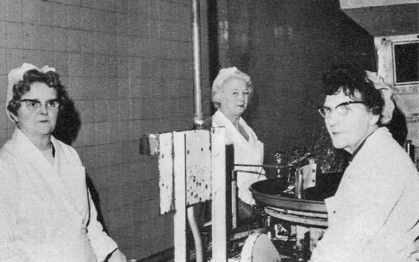 1969 From the house magazine of Cadbury Schweppes who had just acquired Goldhanger Fruit Farms. "Three ladies whose combined service totals 41 years-Mrs Nellie Smith, Elsie Ruffle and Olive Brice operating a machine which fills cans, each with the correct weight of product, at speeds up to 220 a minute." (Courtesy Lee Morrison)