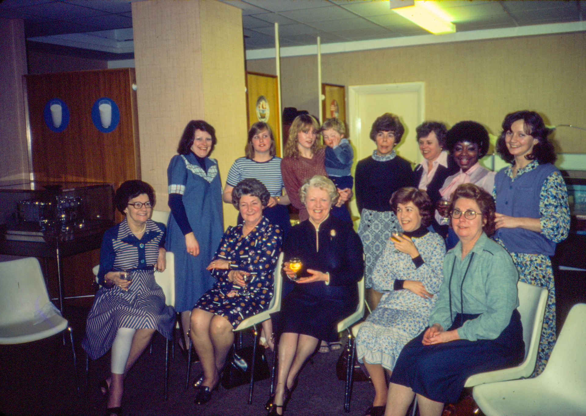 1981 South Morden visitors room. Retirement party for our receptionist/ switchboard operator Joan. Seated L-R Vi Penford, JoJo Holland-Spinks, Joan Wilkinson, ?, ? Standing L-R Sue Burton, Gay Arnold nee Waterman, Tracey Hayes holding Jamie Burton (Chris and Sue's son), Beryl Jones, Jackie Bethell, Gladys, Breda Nash.