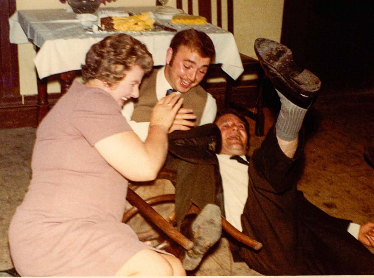 "Mrs Nancy Carswell, sitting on upturned chair Mr Brian Lakelin (working in carton store). Party at a local pub" (Courtesy Joe Lyons)