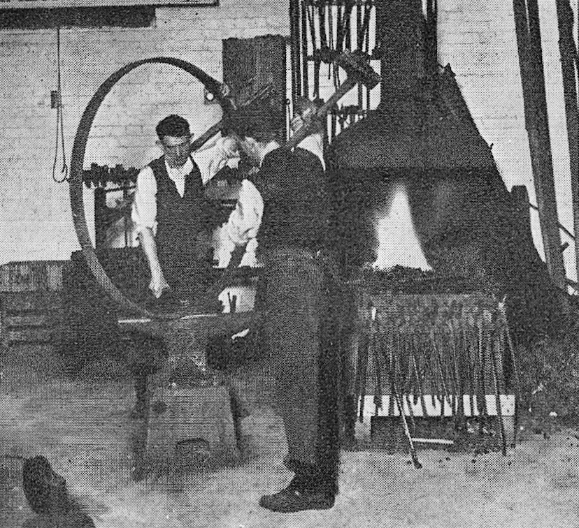 1911 T.H. Lewis staff fixing tyres, which were made-to-measure from flat steel; it was quite a job putting in the rivets. (1960 Picture Set from Express News Christmas edition)