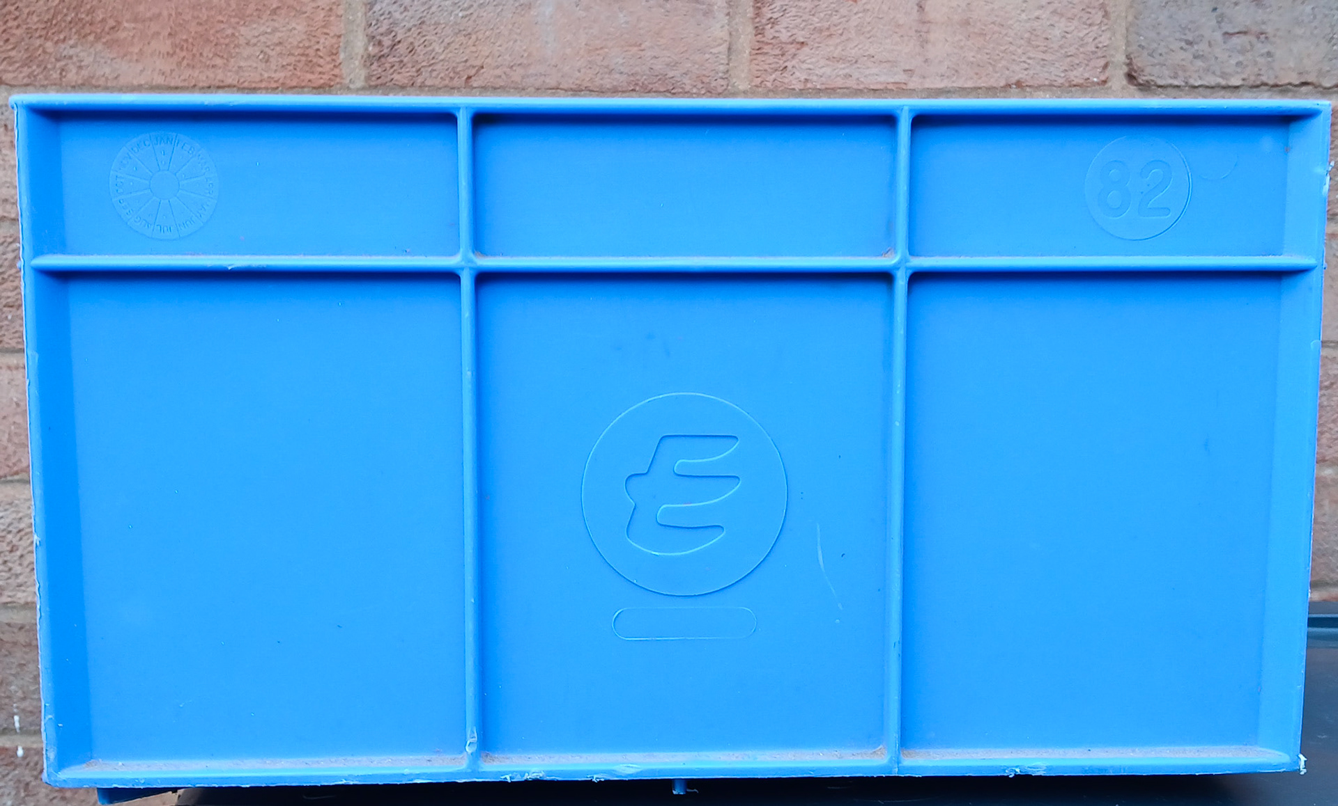 1990's? North Tawton Cheese Storage crate. Ron Iles comments "Good strong boxes but a b*gger to get the 40 pound block cheese out." Tim Schofield comments "These were modified after a couple of years, holes were drilled into the bases. This allowed air into the bottom to release the vacuum/suction that the cheese caused." Dai Williams said "Remember these well. Never had enough in stock for the April flush !! Also the 4-post metal pallets that they were loaded onto for storage. No mobile racking required in those days. Mark Hudson adds "The circles at the top left and right of the crate show the month and year of manufacture... 1982 in this case." (Courtesy Phillip Budd)