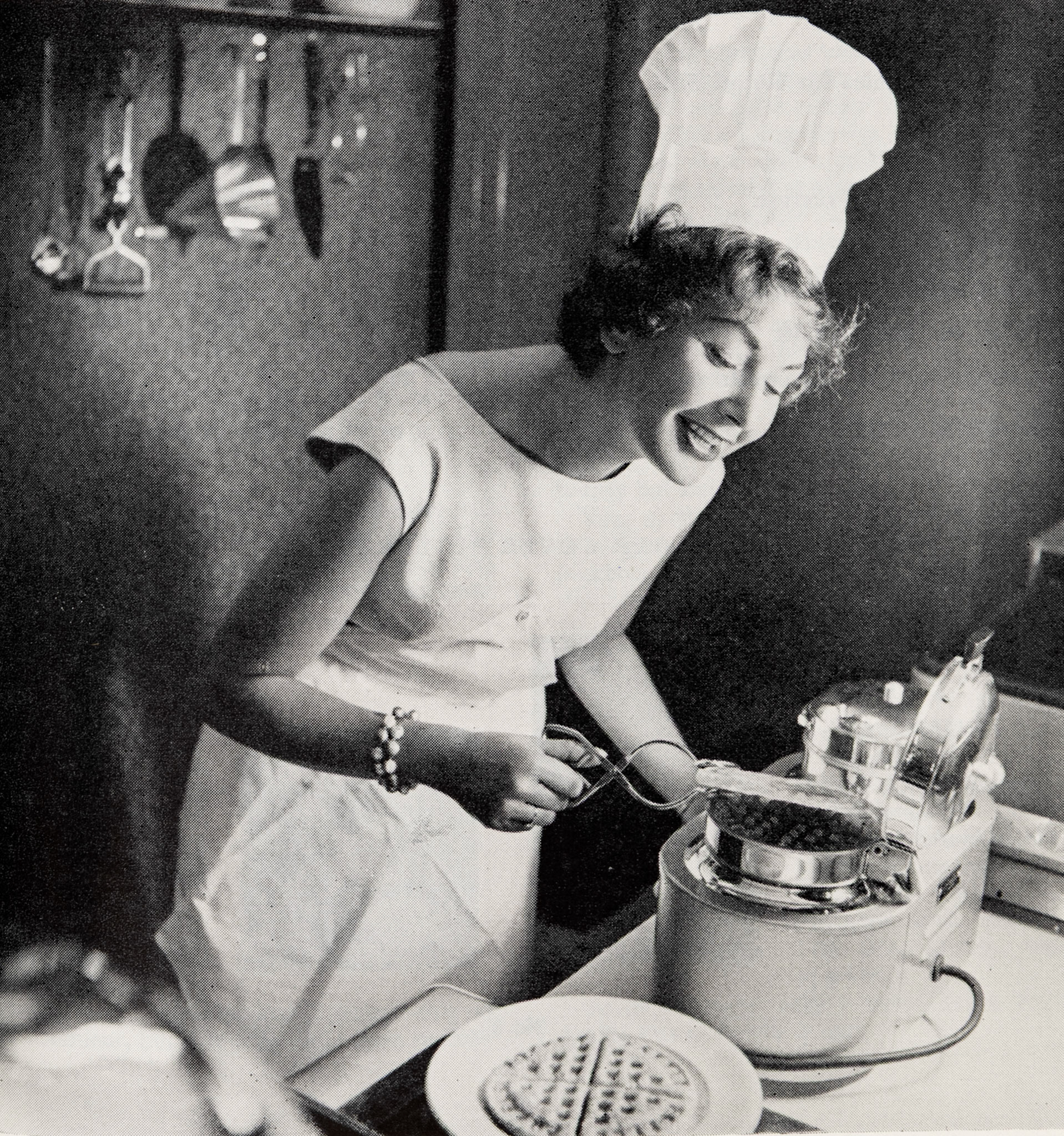1957 Autumn Front Cover-"Housecraft-Television girl Eve Vitt tries out a waffle-iron in Great Tower Street restaurant."