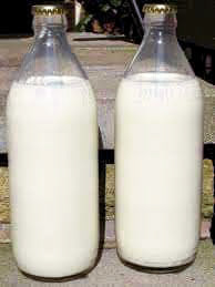 Sterilised milk glass bottles with crown cap. Michael Sherrington comments "It was always possible to tell if the bottle had been batch sterilised or sterilised via an automated system. if the boil mark was around the neck of the bottle it was batch sterilised. if the boil mark was longways down the centre of the bottle it was sterilised via an automated system."