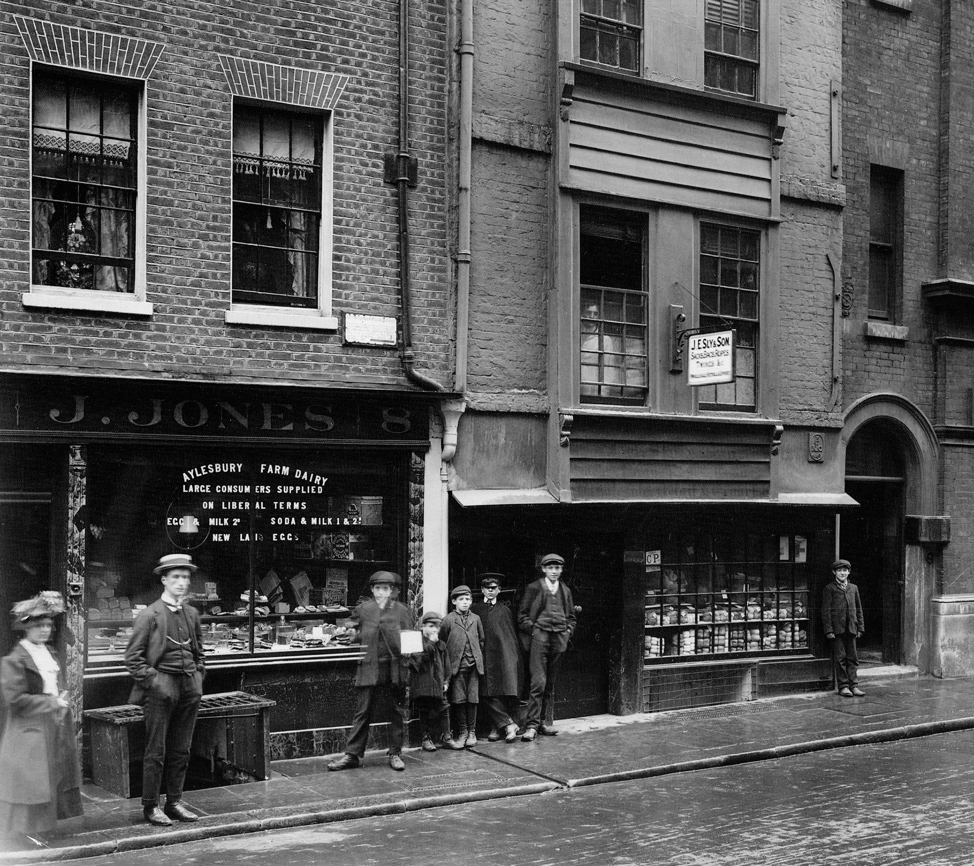 1909 J Jones Dairy Shop at 8 Jewry Street, Aldgate EC3 was built in 1650, and survived both the Great Fire and the Blitz before succumbing to a fire in 1946. ] Jones dairy has a fashionable marbled plinth and pilasters and applied lettering divided by the central glazing bar. (Courtesy GLC Historic Buildings Collection)