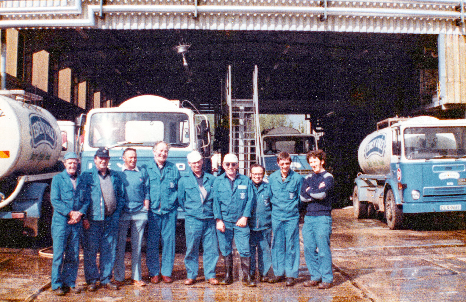 1983 Honiton Drivers: Gordon Hunt, Stan Welch, Sid Maunder, Jack McCormick, Gordon Stapleforth, Roy Jarvis, Gordon Preston, Rob Hawker, Tom Fouracre. James Ayres comments "Also featuring in blue to the right of the picture a Seddon Atkinson 200 series tanker. This series was smaller than previous Seddons and was introduced 1976. It was voted Truck of the Year in 1977. The other vehicle furthest from the camera could easily be an SA as well. The wording on the nearest lorry, hidden by our smiling workers, could spell 'LEYLAND'. (Possibly a Blueline from the early 1970s)." (Courtesy Wendy Hawker)