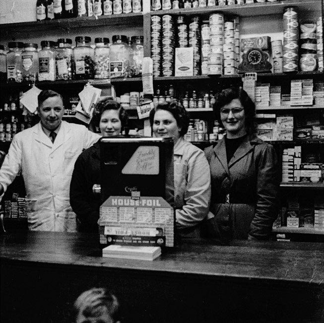1960's? Minsterley Village Shop. "Mr and Mrs Lewis". Len Bailey identifies Charlie Lewis, Anne Lewis née Davis, Sylvia Evans née Ryder. Janet Pitcher and Gillian Davies comment "Wow that’s my mum on the right". Gill Evans adds "Charlie used to have a cream and blue grocery van that called at our house on a Wednesday. Anne became the cook at Minsterley school, after Mrs Rowson. (Courtesy Joe Lyons)