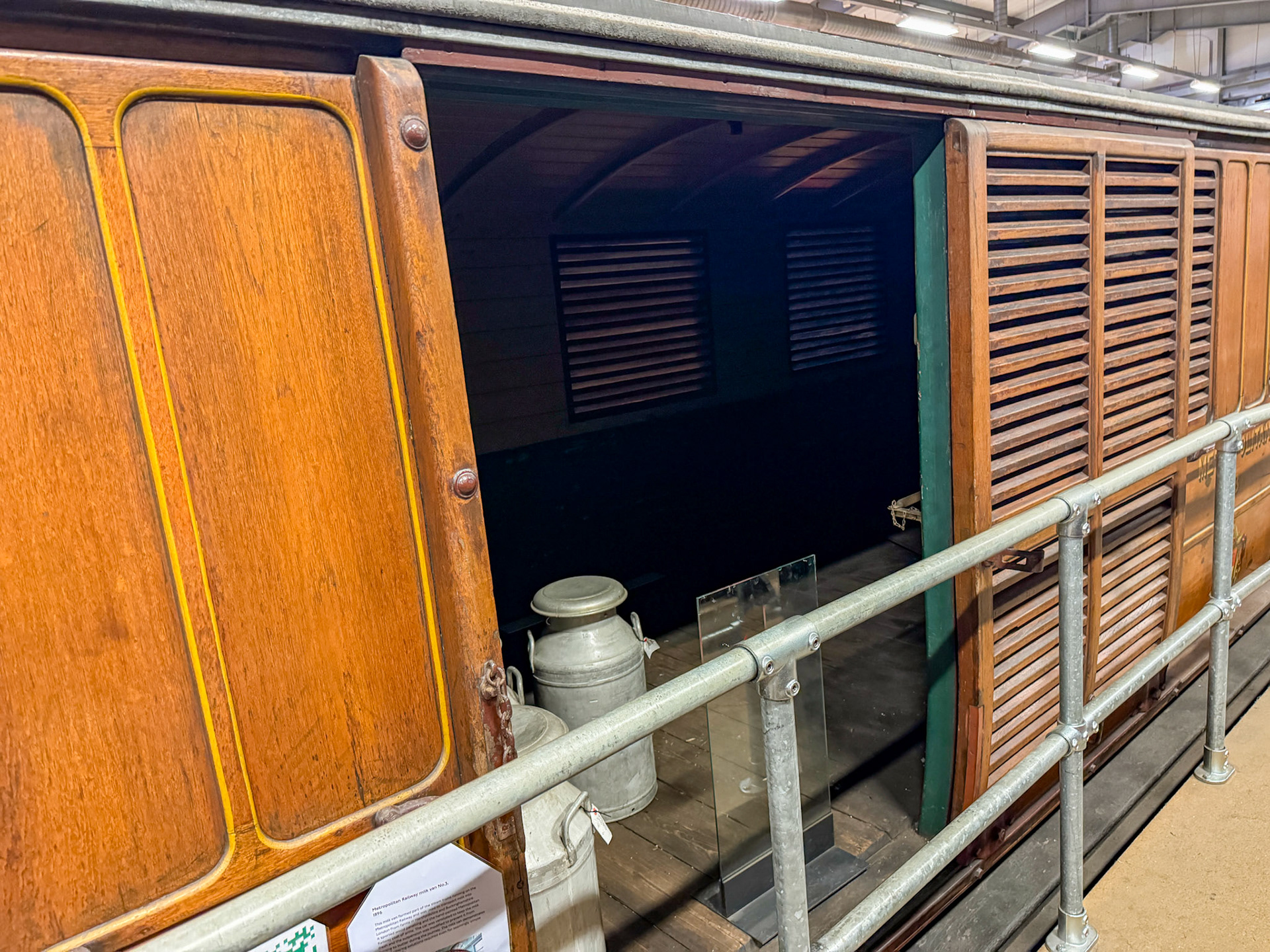 1896 Metropolitan Railway Milk Van No. 3, photographed at the London Transport Museum Depot, Bollo Lane, Acton in April 2025. "This milk van formed part of the steam trains running on the Metropolitan Railway and was used to transport milk into London from farms in Hertfordshire and Buckinghamshire. It sported wood panelling and the hand-painted Metropolitan Railway coat of arms. The car was ventilated to keep the milk fresh and the suspension was modified to prevent it from turning to butter during the journey. The milk van demonstrates the engineering solutions required even for seemingly simple tasks." Accession: 1981/540. Express Dairy Tales collection.