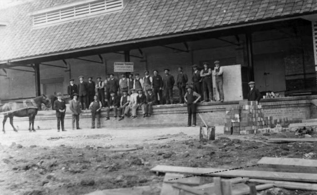 1908 Wootton Bassett Dairy under construction by the Dairy Supply Company. Brian Rebbeck comments "The Dairy Supply Co. had their original Wootton Bassett dairy in 1908 off the High Street, it become a UD Egg depot and then closed in the 1960’s. They moved to Station Road and built the new factory in 1913. Merged with Metropolitan &amp; Great Western Dairies, and Wilts United Dairies in 1915 to form United Dairies". (Still from video produced by Wootton Bassett Town Hall Museum, to mark the closing of the dairy in 2003, after 95 years of operation.)