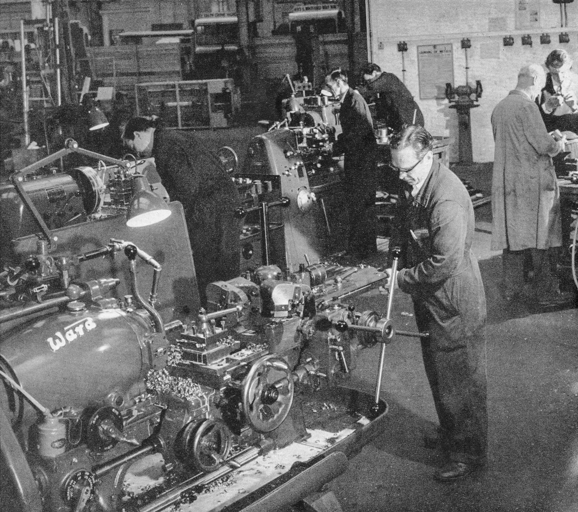 1960's Express Engineering HQ at Stadium Works, Wembley. Philip Boyd comments "That is where I worked, the chap in the foreground is George Barnes, and the foreman in the brown coat is Fred Lawrence. The department at Wembley was situated in one of the old 1926 exhibition spaces, near Wembley Stadium-along North End Road". (From Express Story 1864 - 1964)
