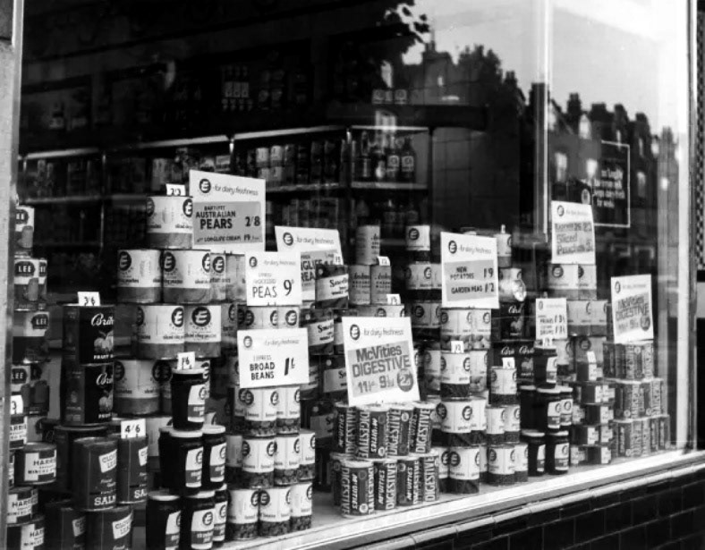 1960's Express Dairy Canons Park shop window display, with a range of food including McVities digestive biscuits, processed peas and sliced peaches. (Courtesy Mary Evans Picture Library)