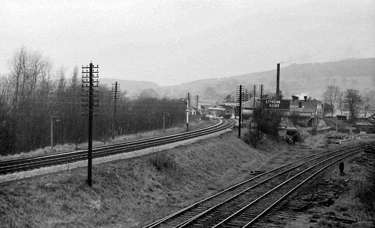 1964c A distant view of Rowsley station with a local service to Derby at the platform.  Dave Walker-Smith comments "The Express dairy and lines to the former station building (now in Peak Village) much in evidence. The dairy was thought to have closed in 1968." (Courtesy Dave Walker-Smith)