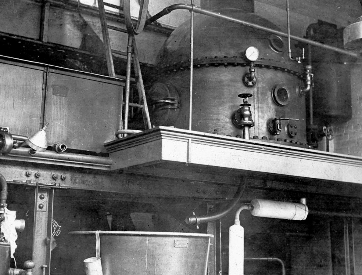 1926 Burgess Creamery, interior, Gartside Street, Manchester. Keith Goodby suggests "This could be a steam buffer vessel; when the valves were opened to the steriliser, there would have been a huge drain on the boilers which could cause a drop in steam pressure in the factory causing pasteurisers to divert. The vessel would act as a buffer to reduce the effect (just a guess though 🤣🤣)."  (Image courtesy of Manchester Libraries)
