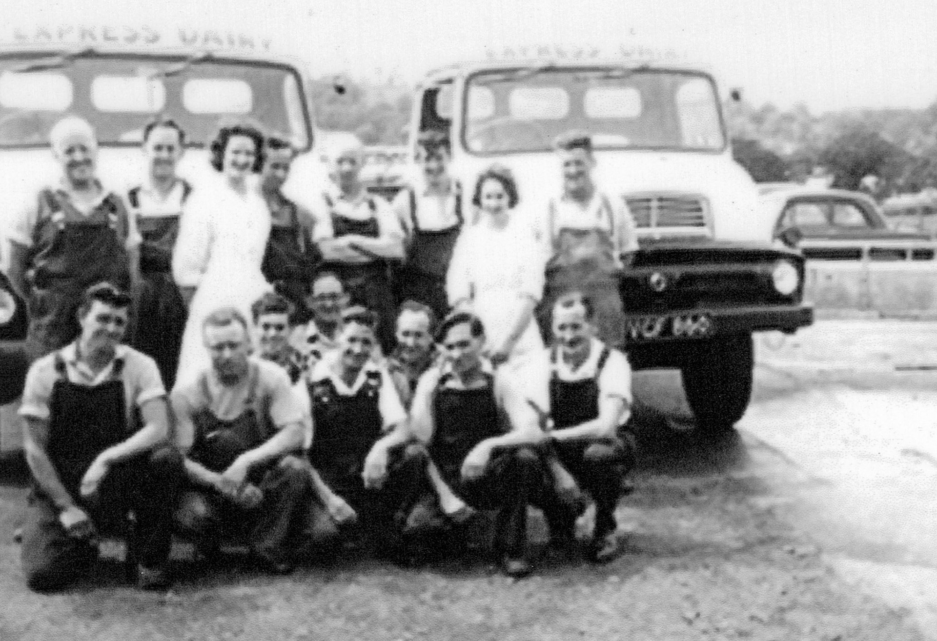 1950's? Seaton Junction Keith Sweetland comments "Seaton Junction by the ramp which is still in our yard. Thames Traders: Raymond Hooper, John Gillingham, Christine Samson, Owen Harris?, Ralph Wake?, Bill Thatcher?, Gordon White?"  Sue West recognises Stan Welch, John Gillingham, George Seaman, Janet and Christine from the Lab. Chrissy Stevens comments "Think that's Mr Gigg 2nd left front row.". Paddy Gillingham comments "The man in the middle at the back, crouching down, is John Gillingham, second on the right crouching down is I think George Seaman."Frances Keene adds "Love this! My Mum is in this pic, right-hand side- Janet Real." John Sanford comments "Ace picture. Ace company" (Courtesy Allhallows Museum, Honiton)