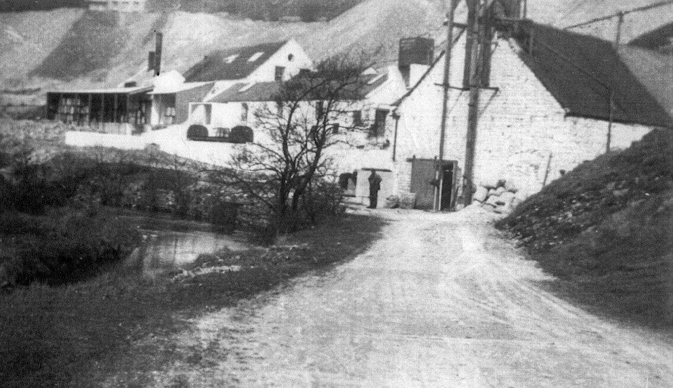1930c Ecton Dairy. View from river level, one of the churn wagons in the background. John Irish comments "... the wagon is one of only two open wagons that the railway possessed and was usually employed carrying churns." (Courtesy Alan Salt)