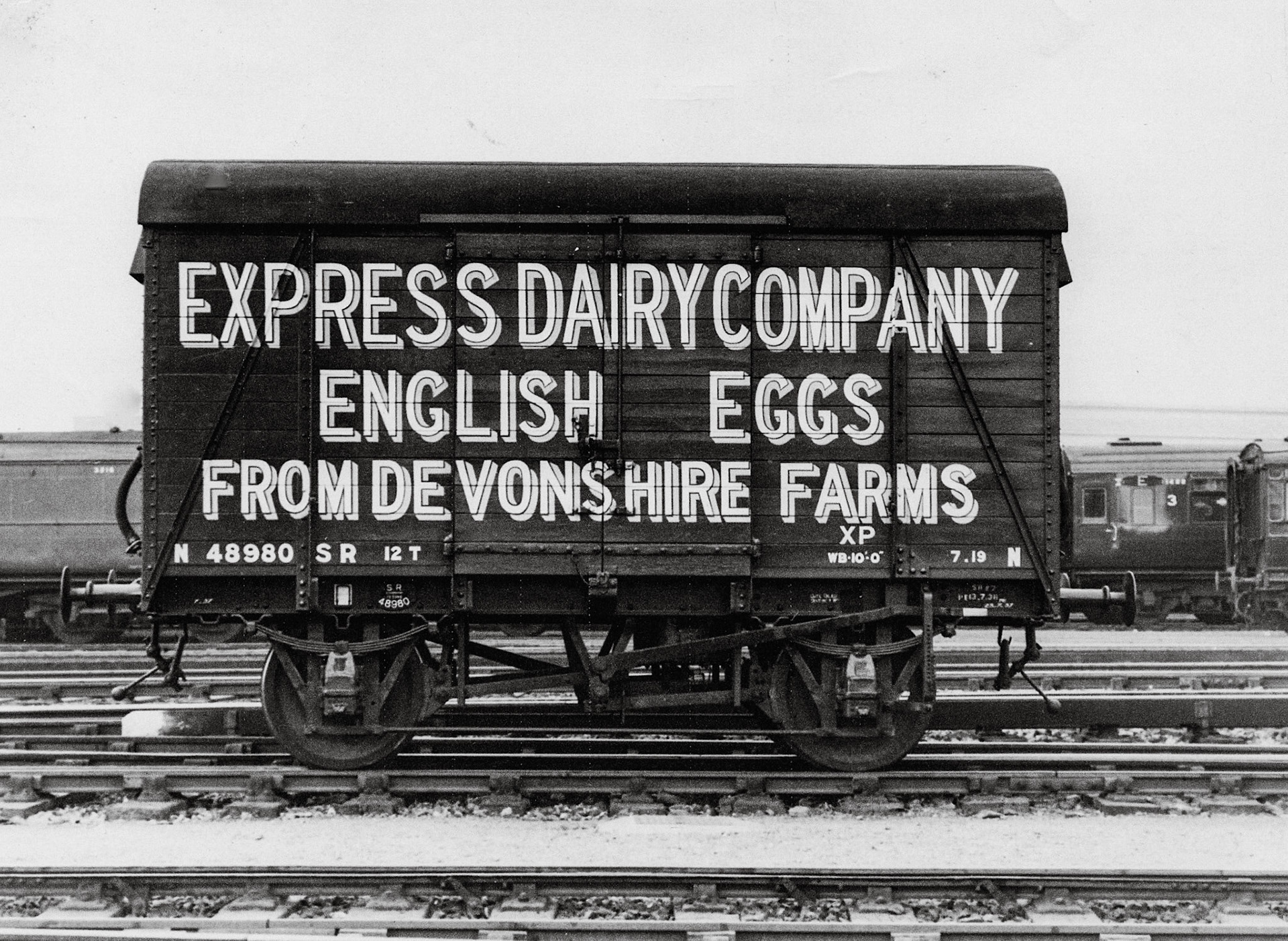 1950's Egg Transport - Eggs for London. James Ayres explains "The wagon is a Southern Railway design made of planks on a steel frame and roofed with felt. Its loaded weight was 12 tons. The letter N at each end of the frame indicate it was fitted with vacuum brakes. They were not of a standard design so the wagon could not be used for freight by rival companies and had to be returned to the Southern. As this particular unit, the property of the Express Dairy, was probably configured inside to accommodate its fragile load it doubtless spent at least half its life running empty. " (Courtesy Keith Sweetland)