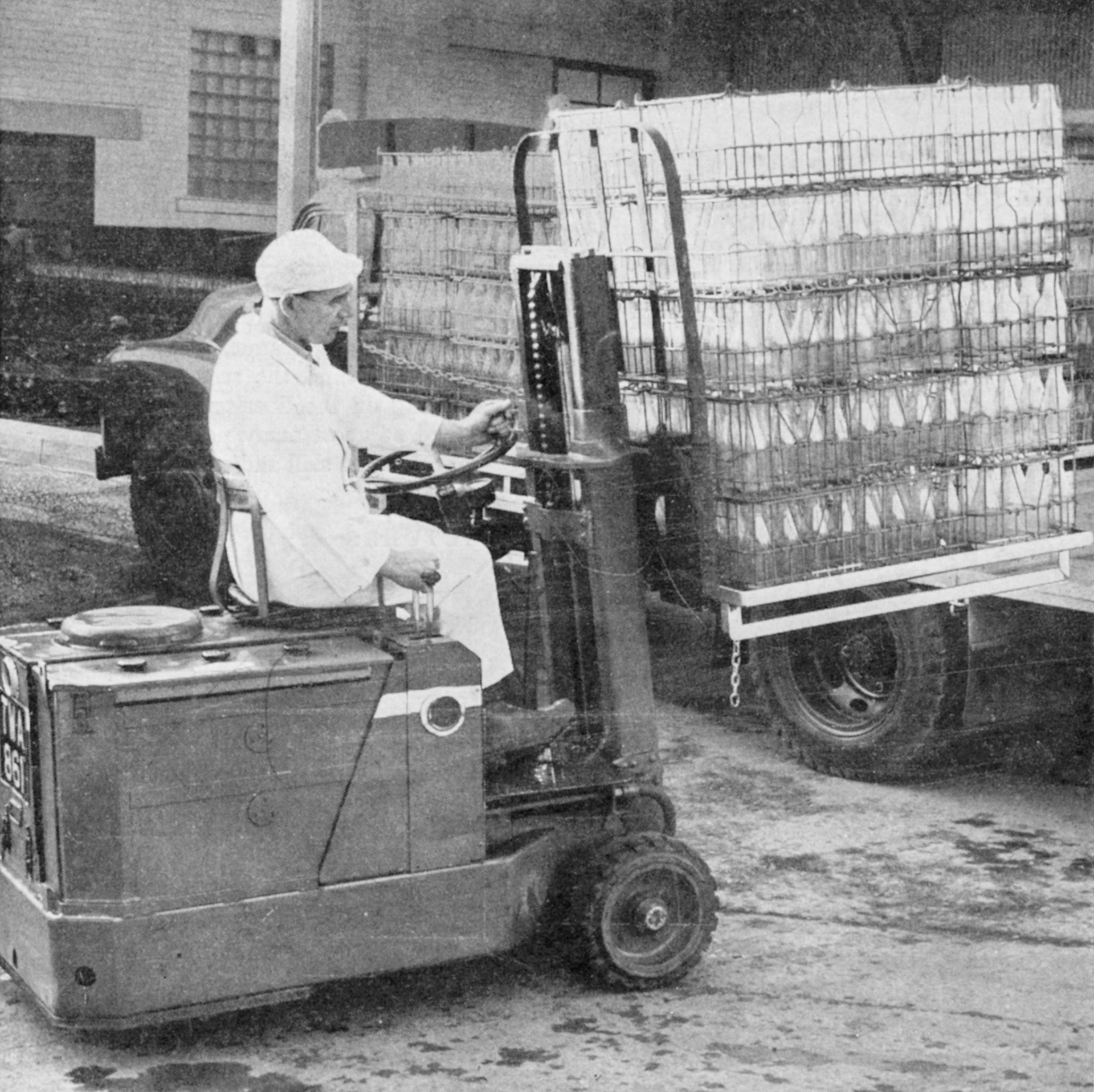 1956 Dewsbury-a modern fork-lift truck helping to speed the turn round of vehicles at Dewsbury (Express News - September 1956 Front Cover)