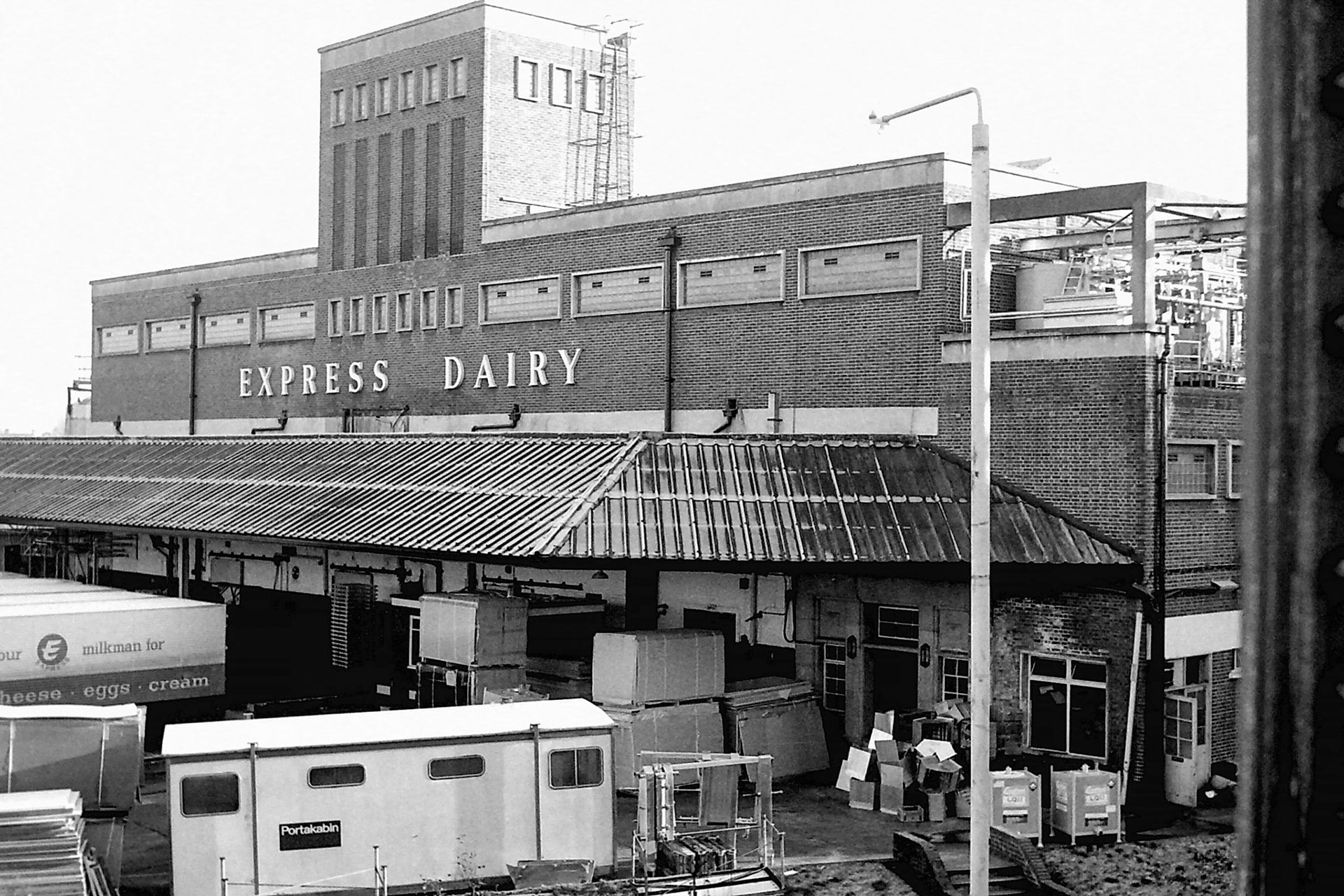 1979 Busy scene in the front yard at South Morden, with materials and contractor's hut temporarily located before the new cold store and loading bays were constructed. (Photographer Sam Jones)