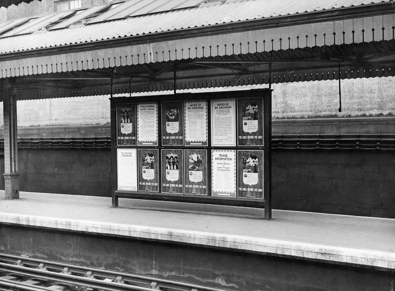 1941 Poster board on platform at Barons Court station, with various notices containing wartime travel information, including "Your dairy produce depends on the Lines behind the Lines". (Courtesy London Transport Collection)