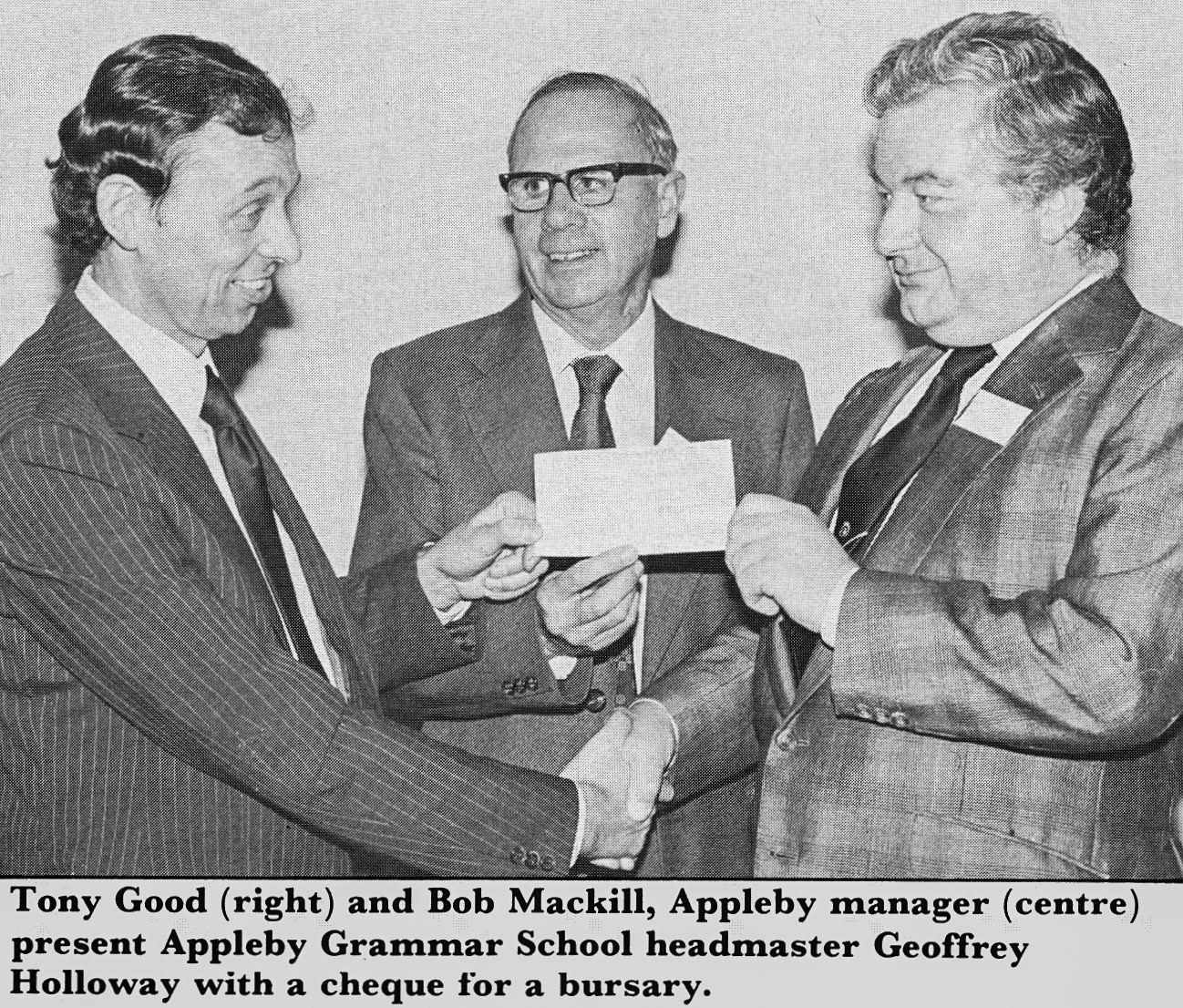 1982 Geoffrey Holloway, headteacher of Appleby Grammar school receives a bursary cheque from Tony Good, with Bob Mackill looking on. (Express News February)