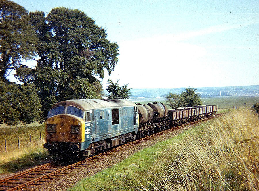 Type 2 loco nearing Fremington, passing Penhill, with Barnstaple in the background. Paul Arnthal comments "Milk and clay empties to Torrington and Meeth." (Courtesy Ken Baker)