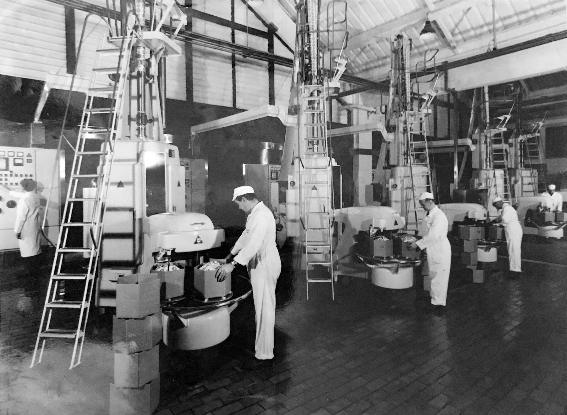 1970's "Battery of five aseptic Tetra Pak filling machines at South Morden - 450 gallons per hour each" Joe Taylor comments "Second operator from left looks like Frank Heath, I remember those days-splicing the paper, checking the sealing strip, the white painful hands from peroxide sterilant and the jammed paper with resulting flare ups". (Courtesy Lindsey Cannon)