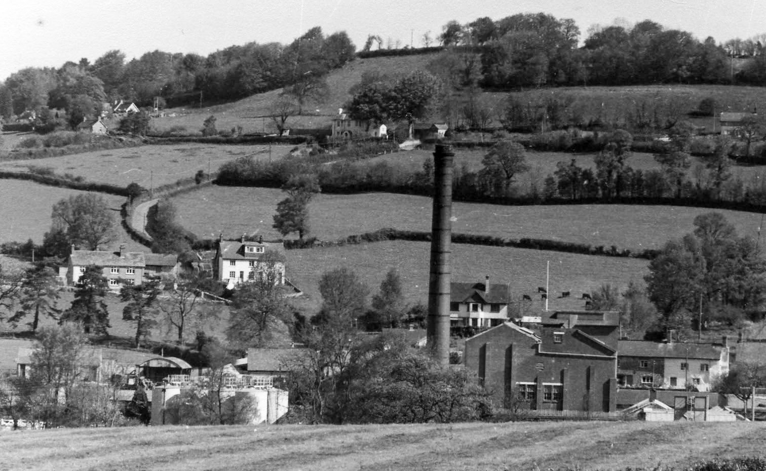 1970s? Hemyock, Devon-"View from Hemyock towards the dairy and Combe Hill, with the station site in the bottom left. You can see the crossing gates where the southernmost siding traversed the road." Express only did egg packing at Hemyock, the dairy later became St Ivel. (Courtesy Discovering Devon, Somerset and beyond FB)