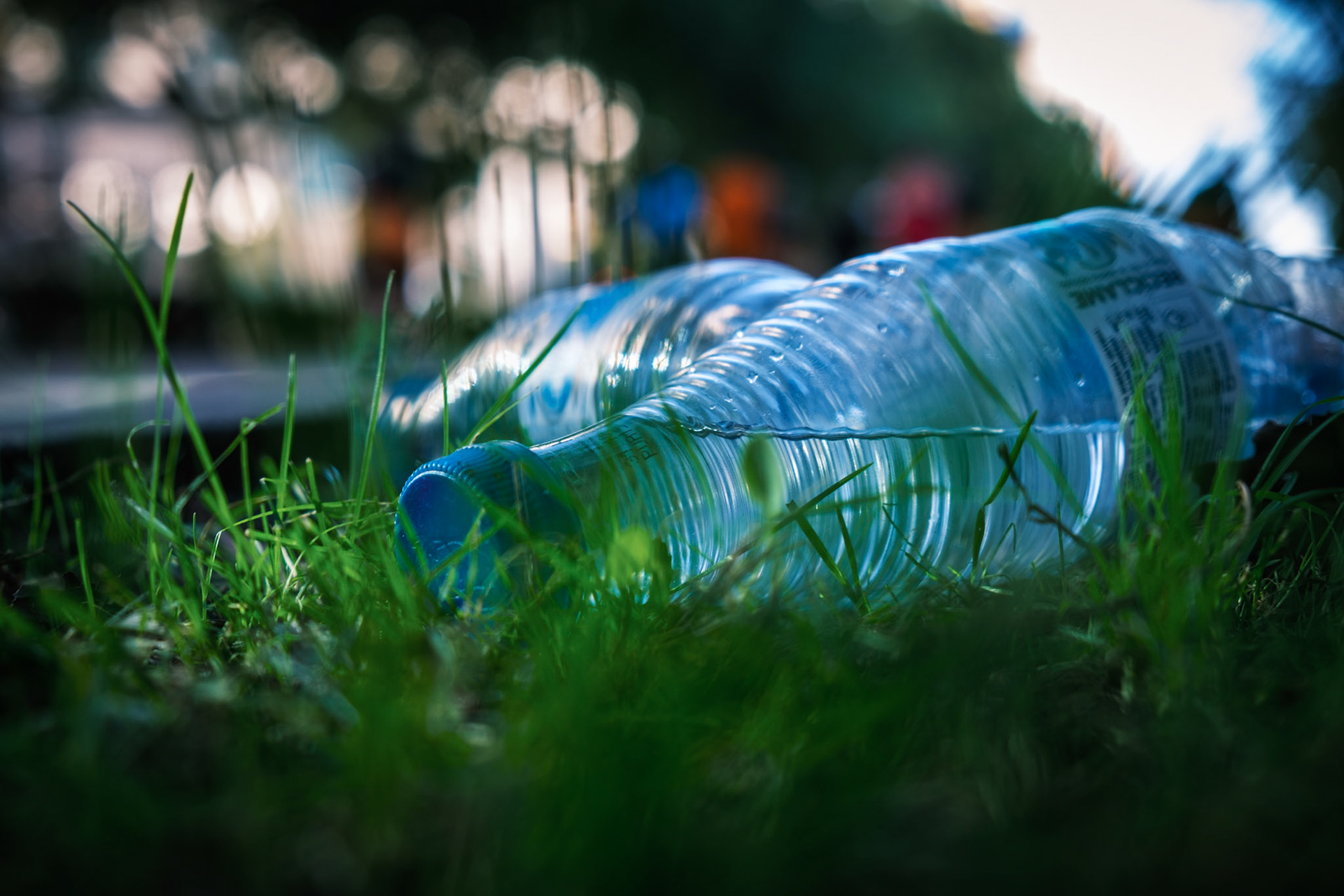 Botellas medio vacias tiradas en el suelo después de una carrera de running Botella tirada en el suelo para reciclar después de una carrera de running