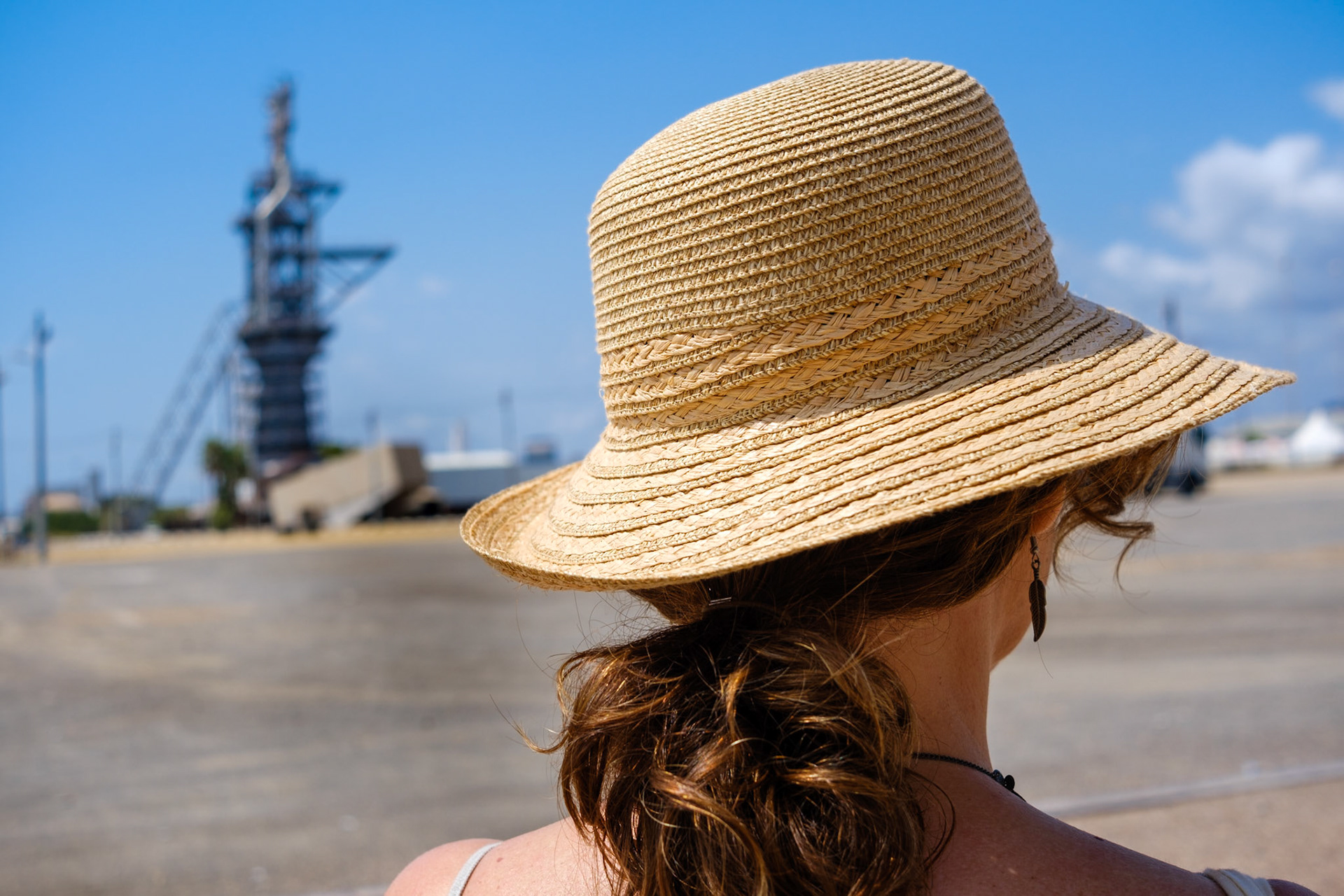 Mujer con sombrero mirando la extructura industrial del museo de los altos hornos de sagunto en valencia