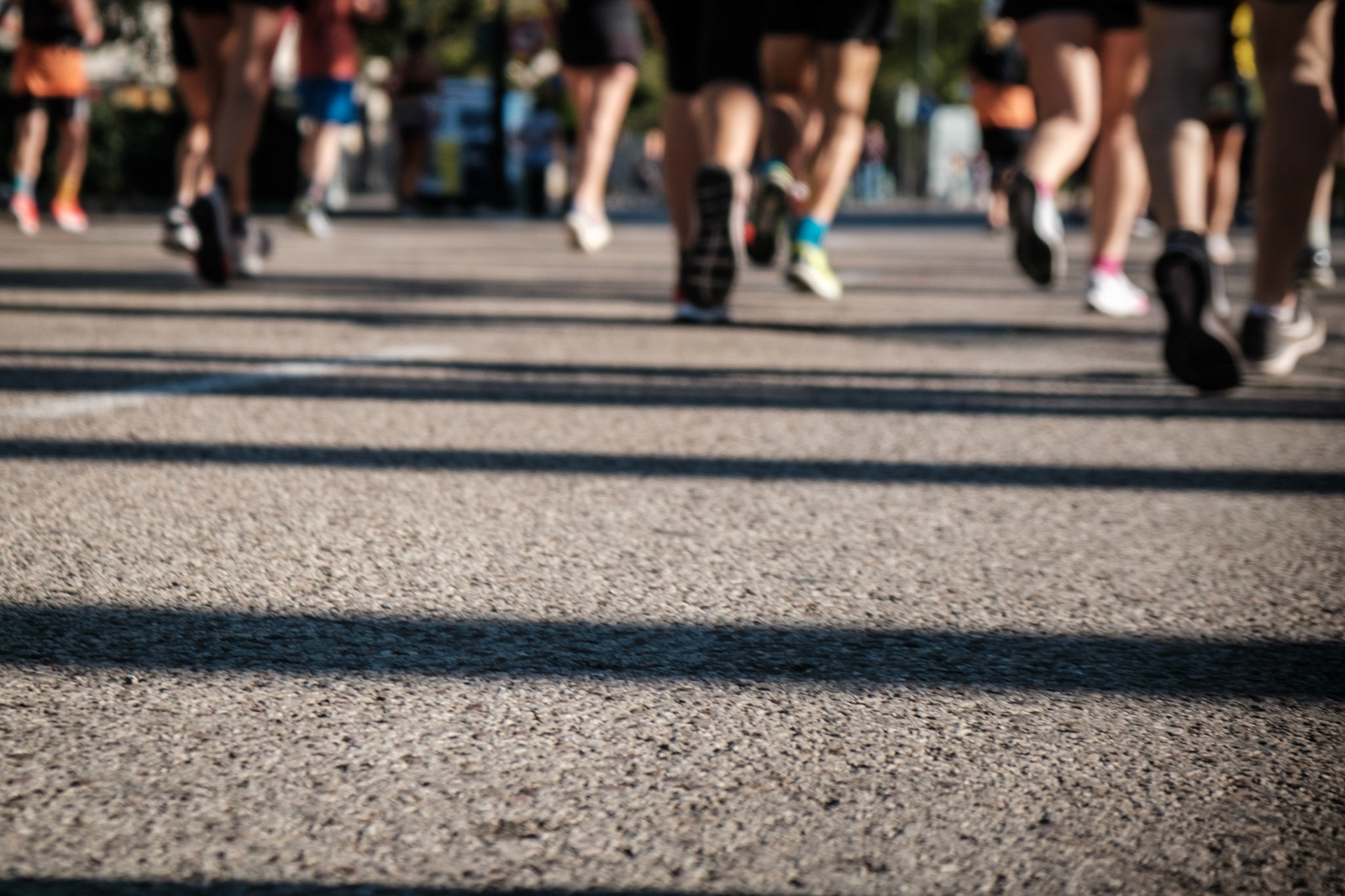 Gente practicando running sobre el asfalto corriendo con sensación de velocidad