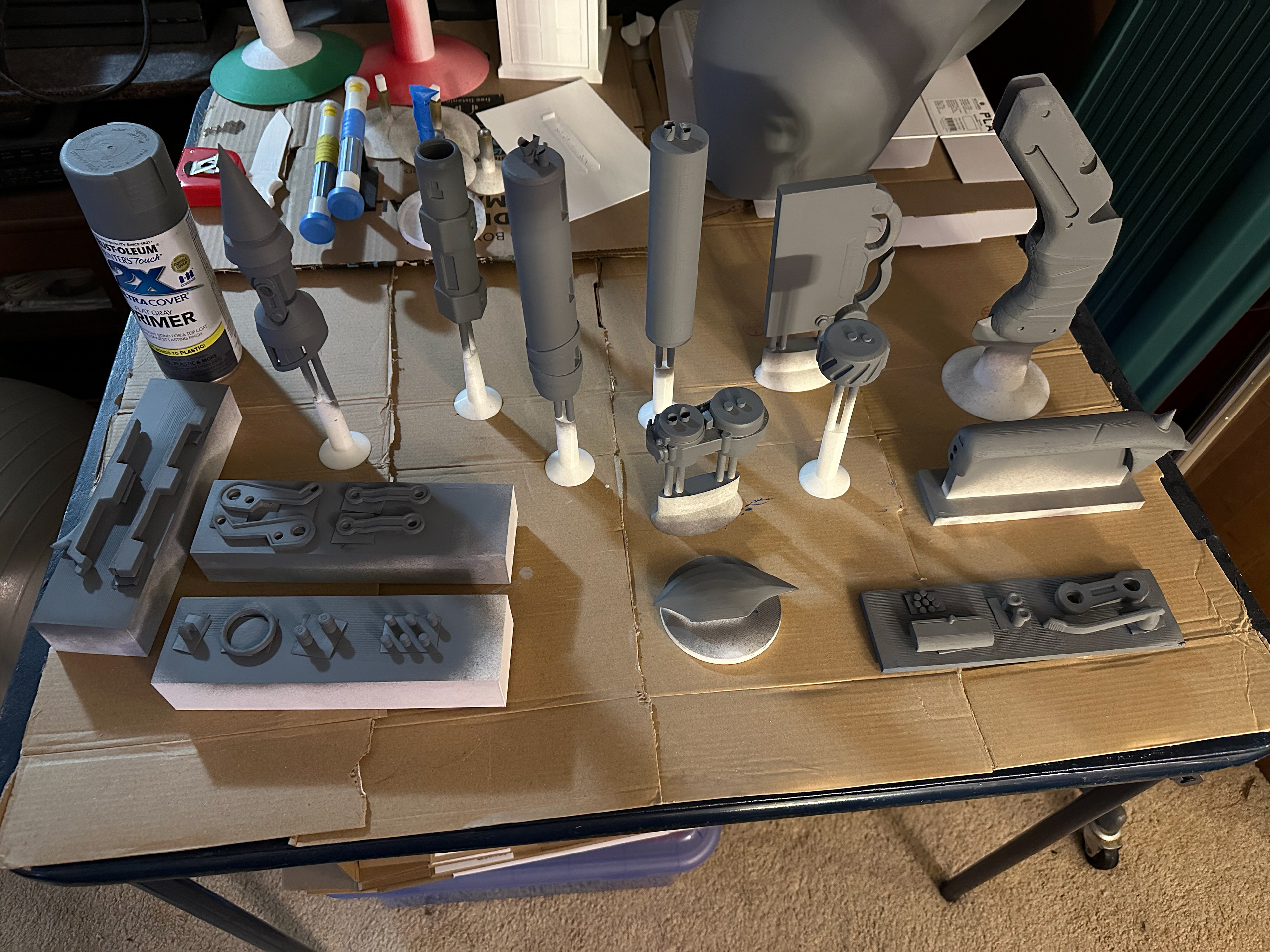 Pieces arranged on painting stands with a coat of primer