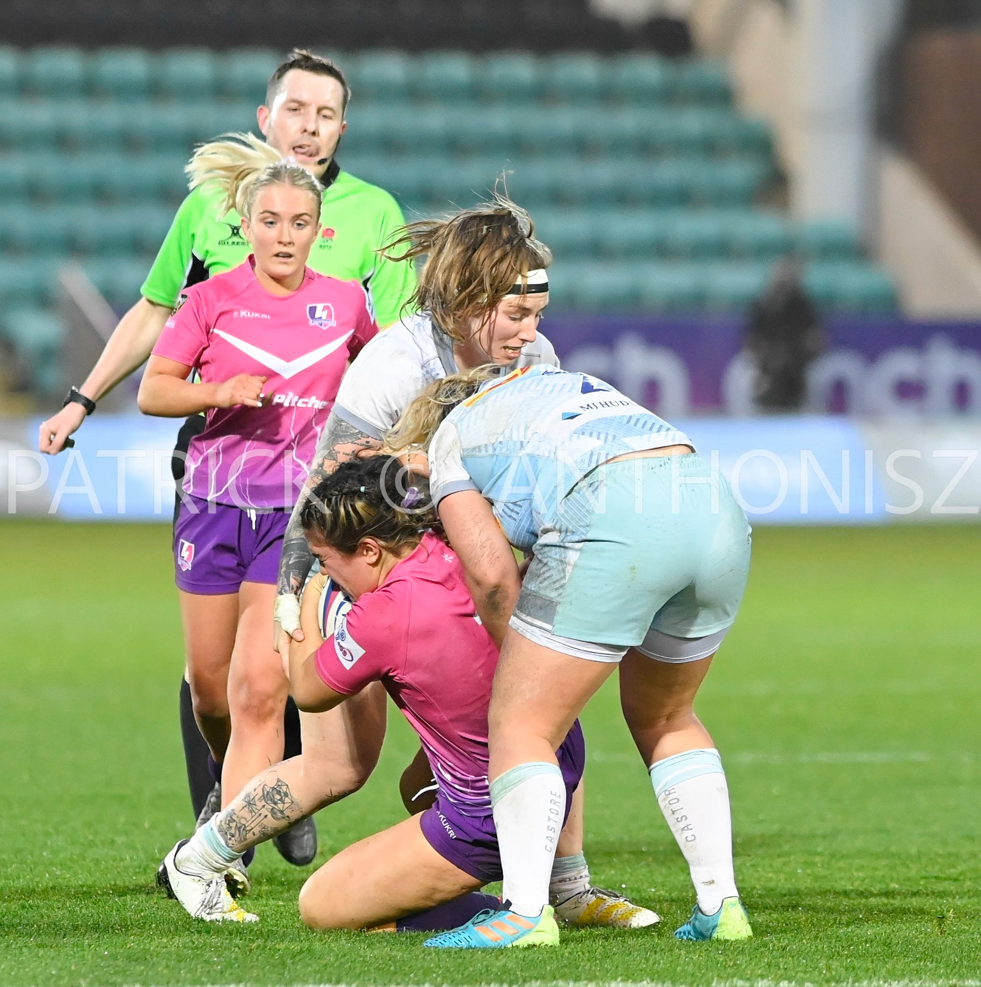 NORTHAMPTON, ENGLAND- Nov -27 - 2022 :  Bryony Field of Loughborough taken down by Harlequins women Rosie Dobson and Jade Konkel-Roberts  during the match between Loughborough Lightning Vs Harlequins at Franklin's Gardens on November 27, 2022 in Northampton, England