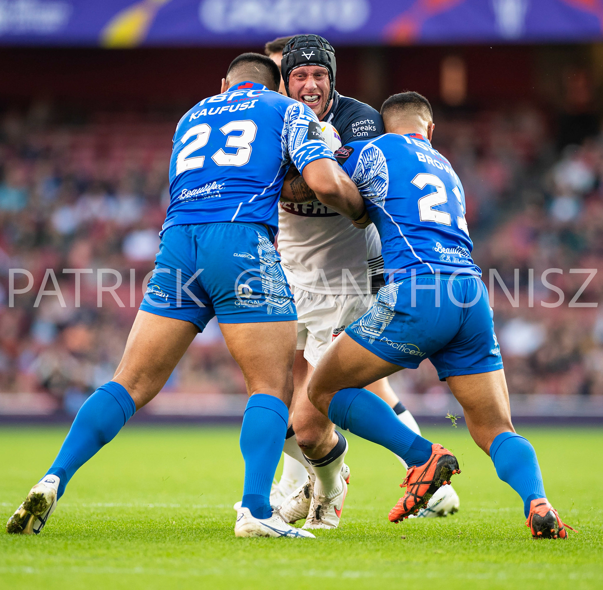 London  ENGLAND - NOVEMBER 12. Chris Hill of England  under attack by Jaydn Su'a of Samoa and Fa'amanu Brown of Samoaduring  the  Semi Final between England and Samoa at the Emirates Stadium on November 12 - 2022 in London, England.