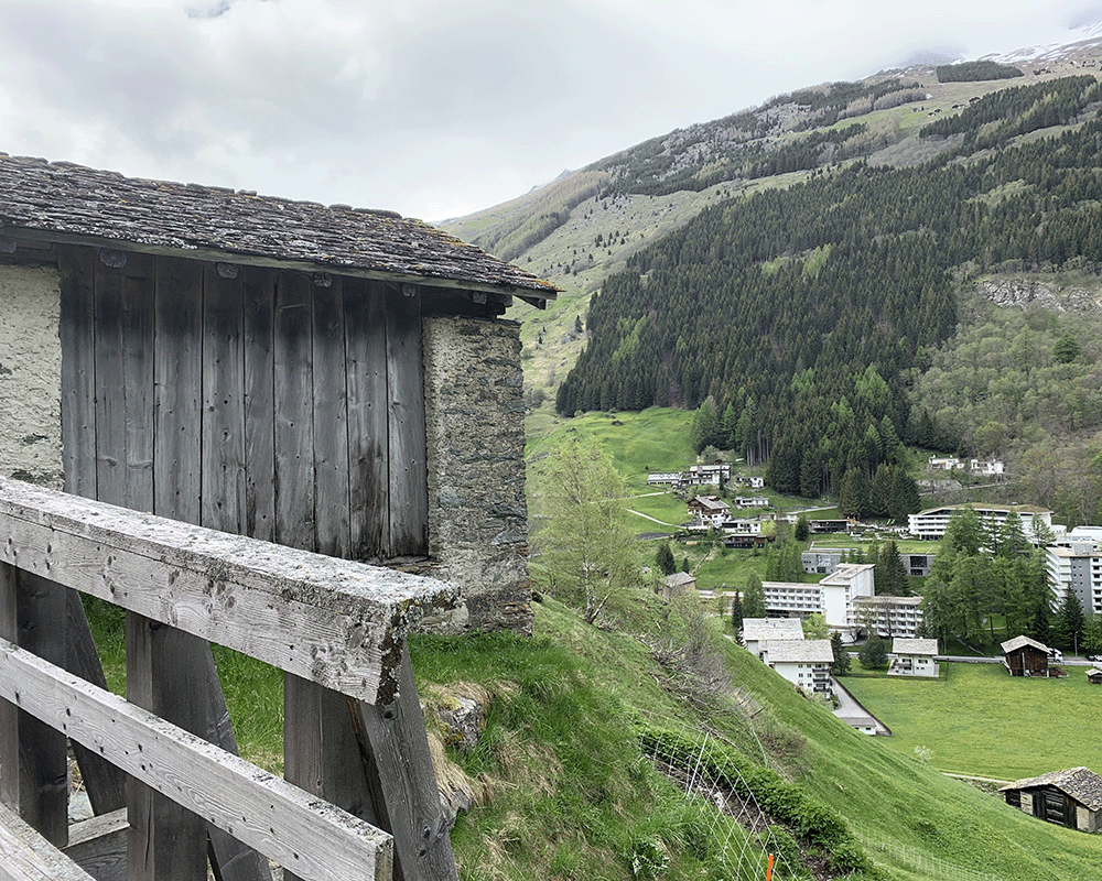 Therme Vals and surrounding hotel complex in Vals, Switerland from the other side of the valley with a vernacular farm hut sheep shed in the foreground