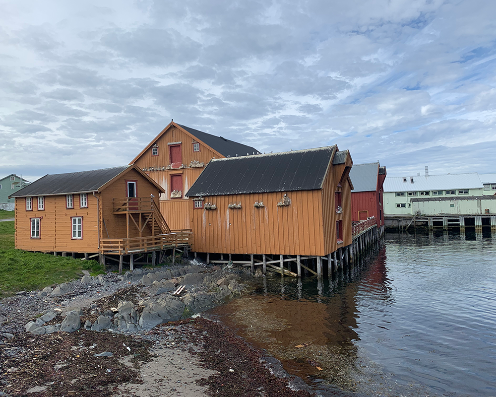 Pomor Museum in Vardø Norway on the Island's Central Harbor in an orange building on stilts with seagulls