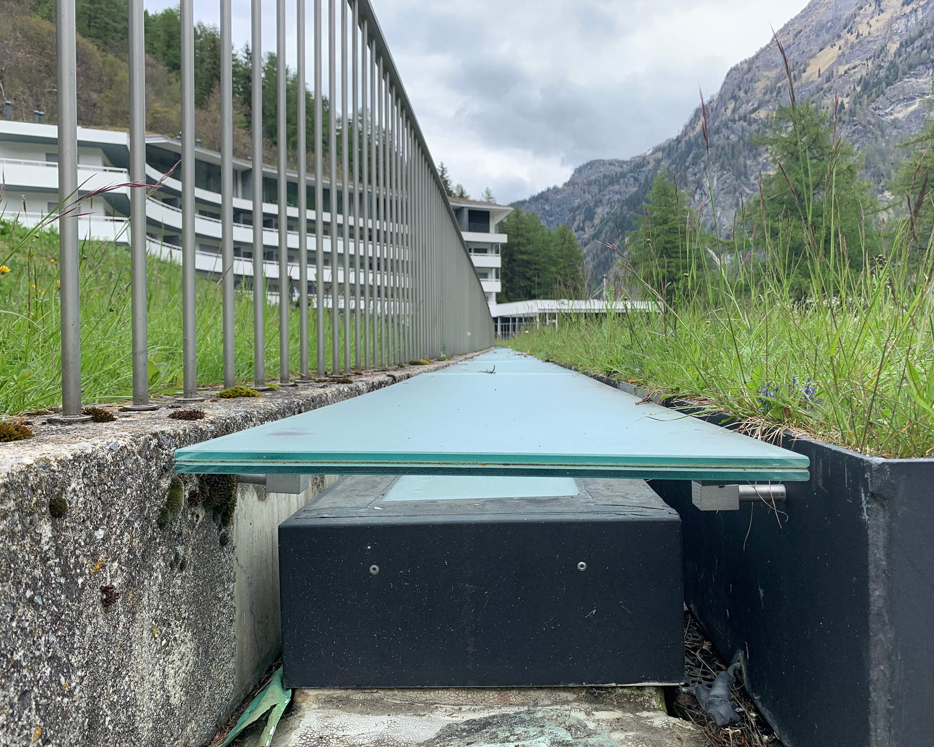 ceiling reveal and expansion joint at Therme Vals in Vals, Switzerland on green roof with hotel and mountain in background