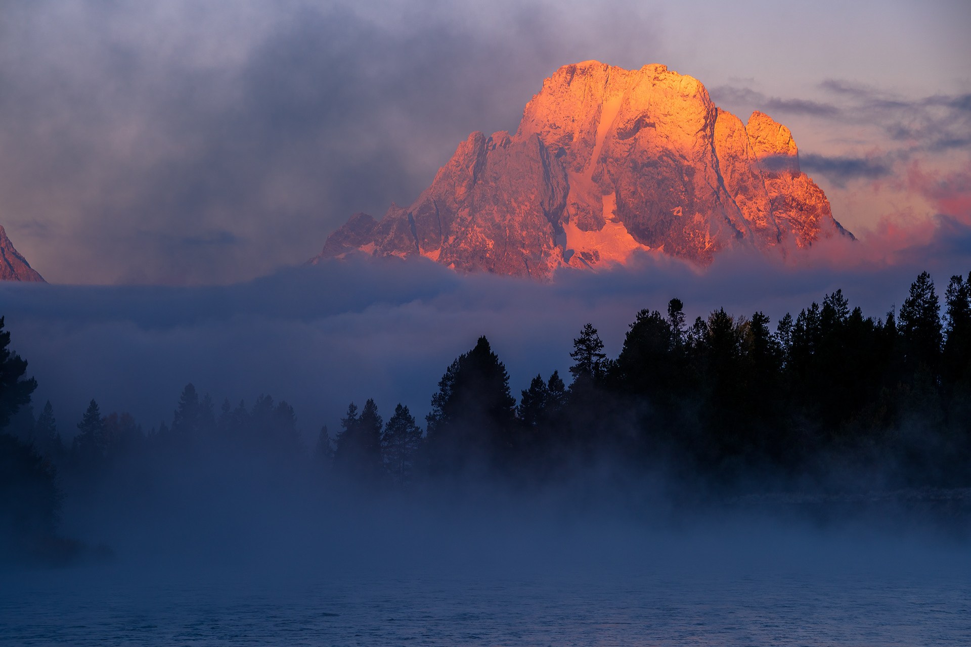 Mount Moran with Early Sunlight Stands Above Foggy Snake River