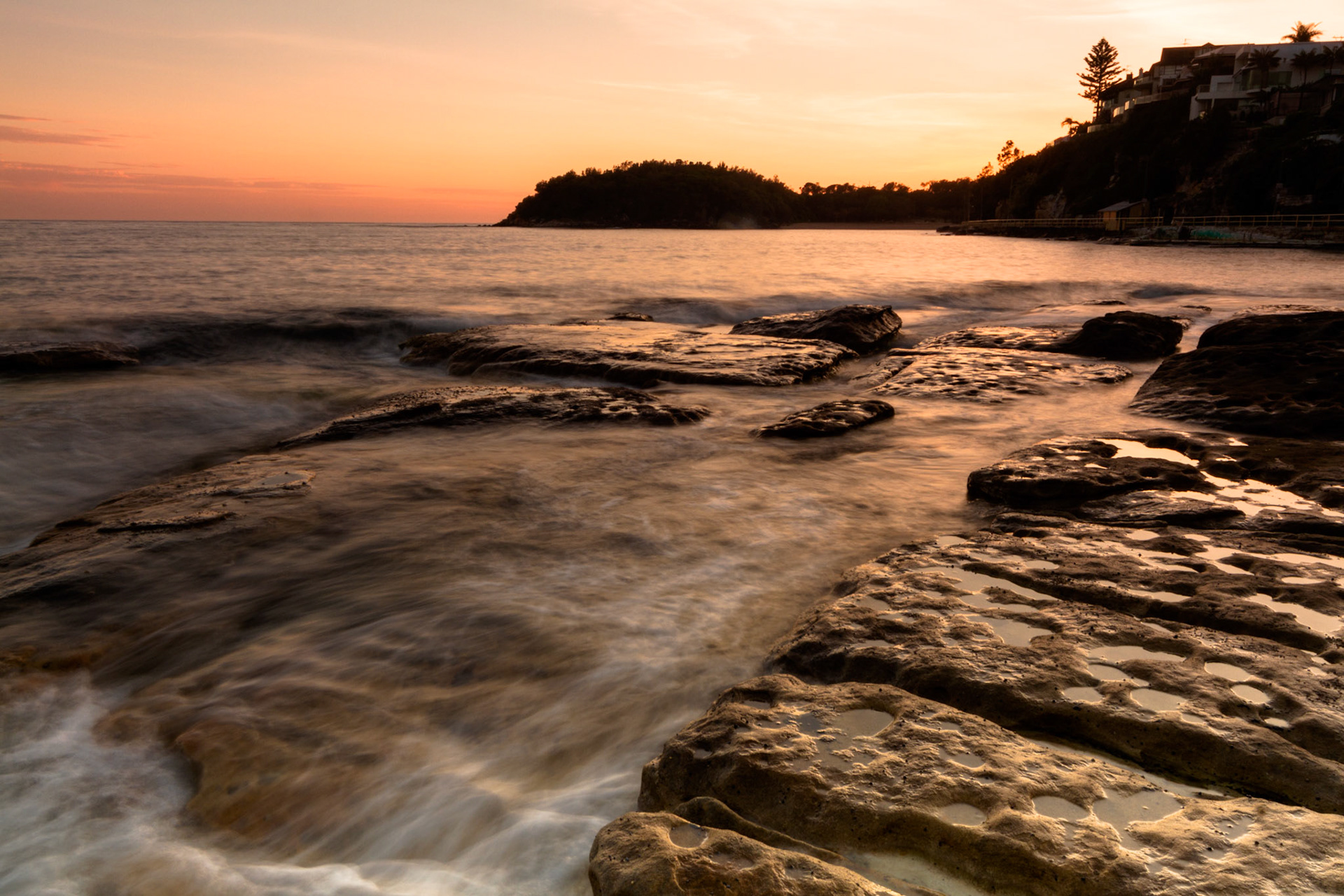 The waves wash over the rocks in a fine mist in Manly, NSW, Australia.
