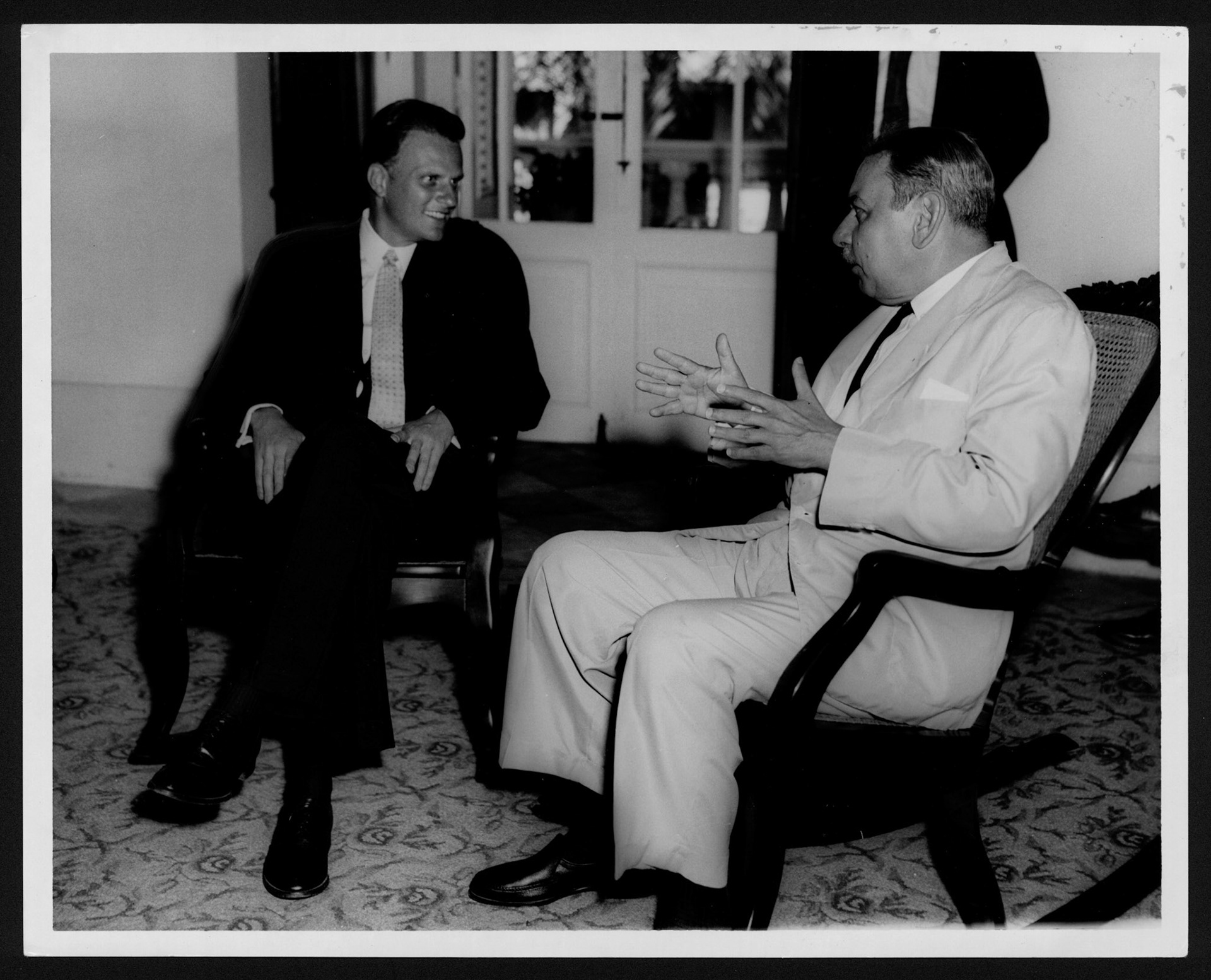 Gobernador Muñoz Marín y Billy Graham conversando en sillones de La Fortaleza.1958