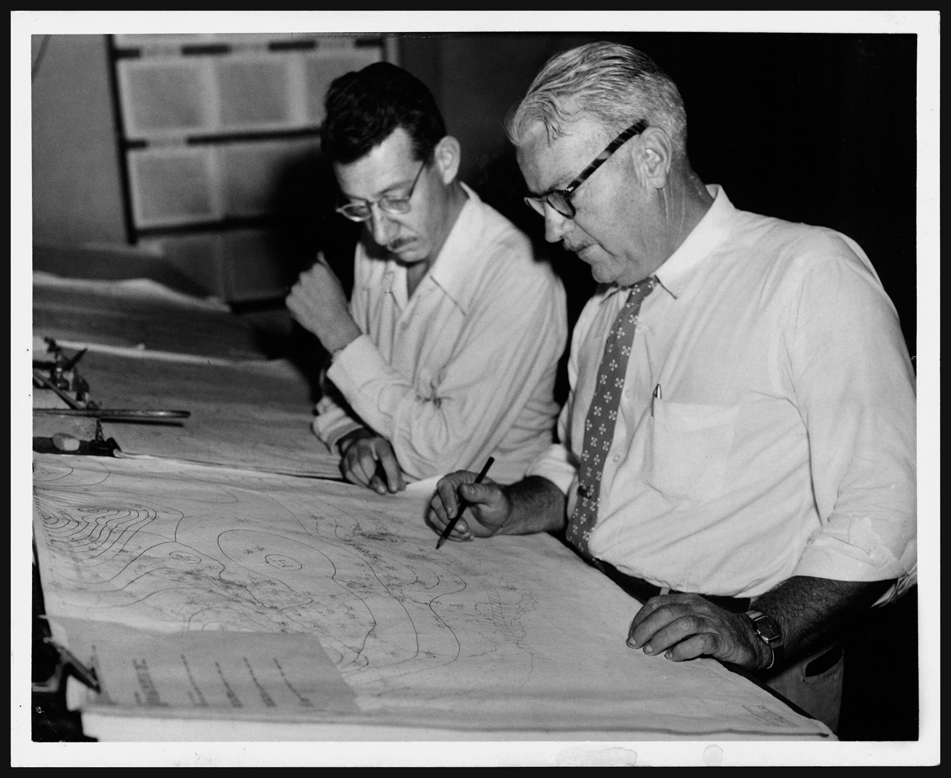 Oficiales del Negociado del Tiempo observando mapa con trayectoria de Huracán Hazel.Octubre 6, 1954