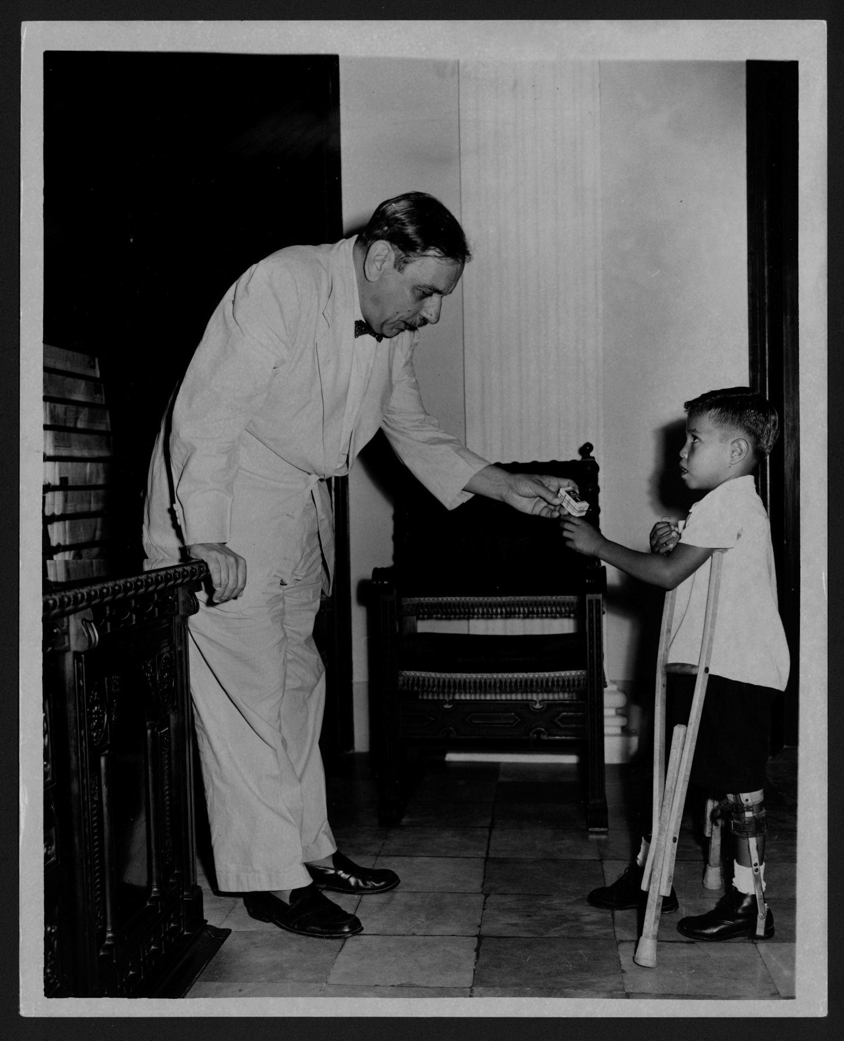 Niñito lisiado entregando a Luis Muñoz Marín vacuna contra la parálisis infantil.La Fortaleza.Enero 22, 1954