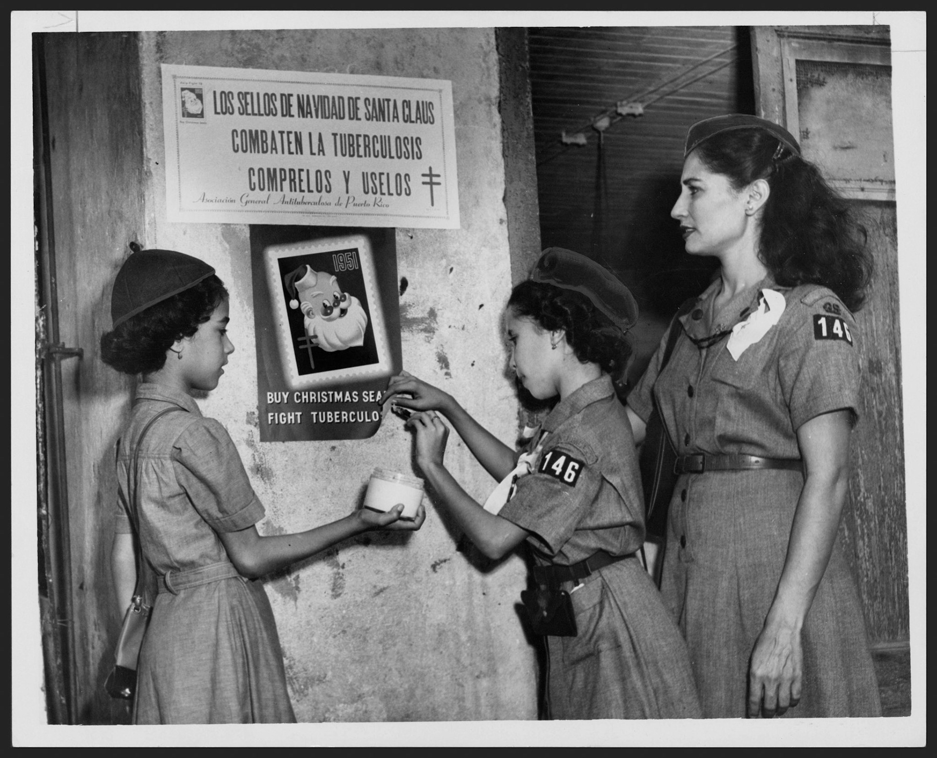 Niñas escuchas colocando letreros de propaganda para los sellos de la campaña contra la tuberculosis.Noviembre 11, 1951