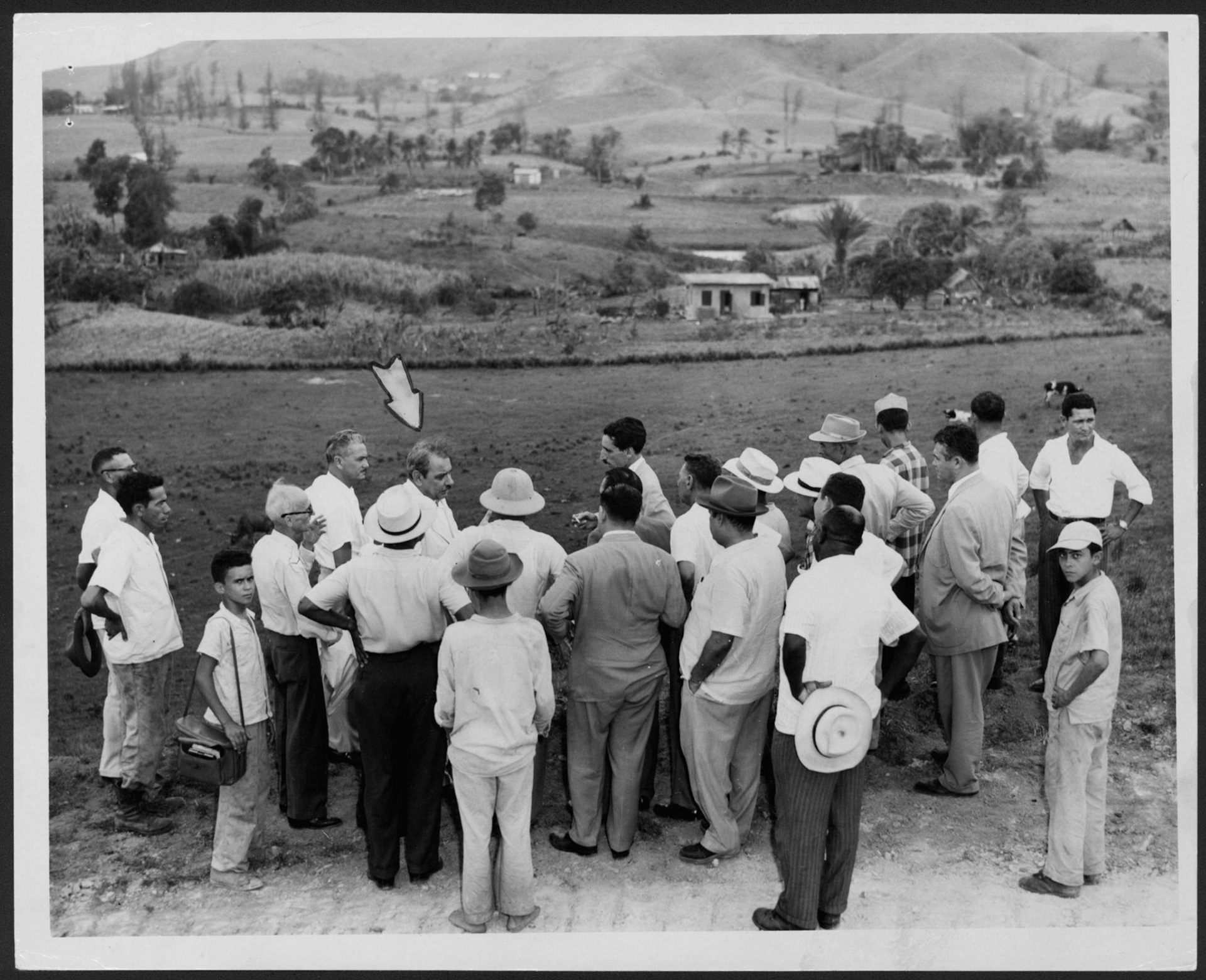 Gobernador Muñoz Marín en camino vecinal explicando a periodistas y vecinos el proyecto del barrio Jaguas.Gurabo.Julio3, 1953