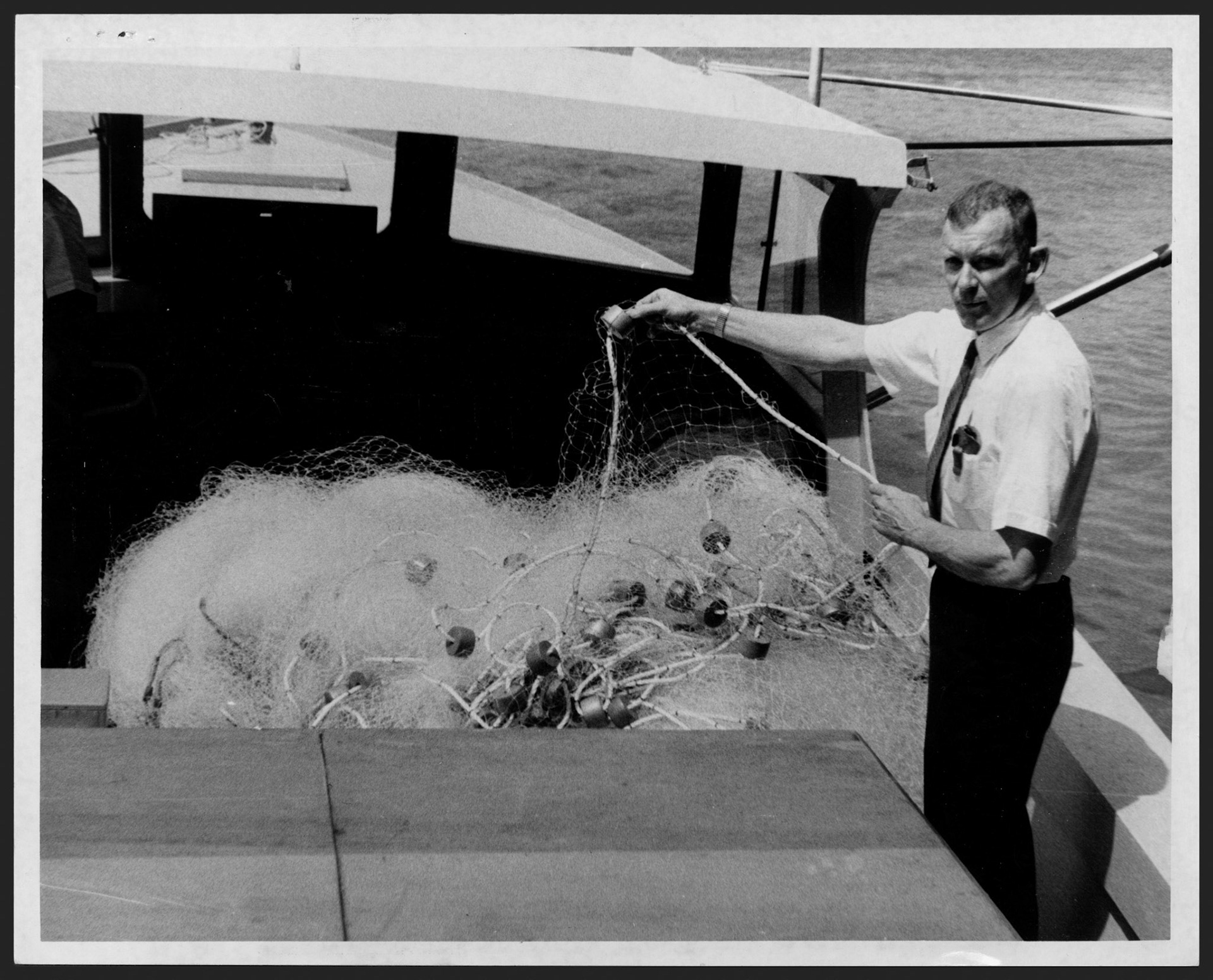 Rolf Juhl en una lancha mostrando red de pescar de fino hilo de nilón.Junio 2, 1967